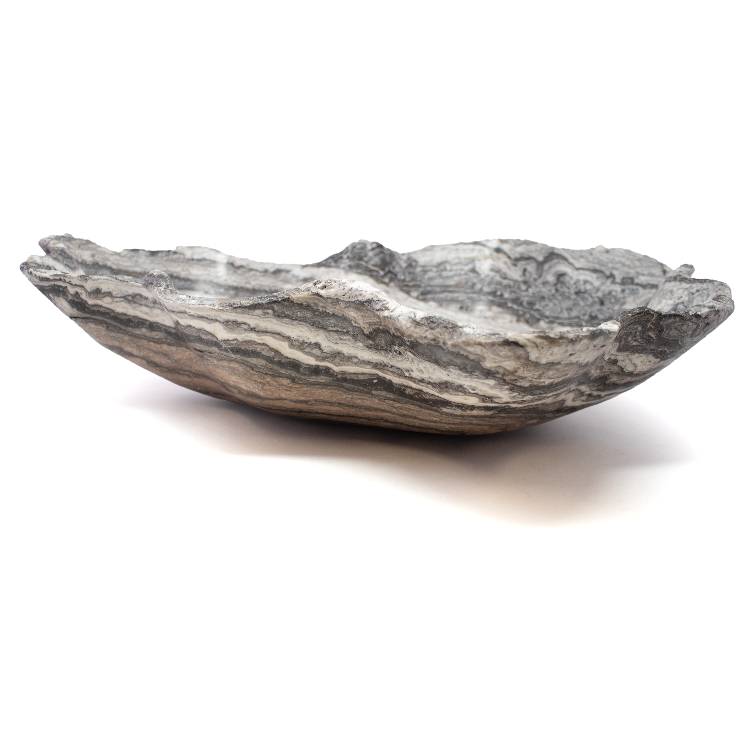 Sculpted from rare Serpentine Zebra Onyx, this vessel is a study in bold contrast and natural refinement. Dramatic black and ivory veining flows in hypnotic bands across the smooth, high-polish surface, echoing the wild elegance of its namesake. Each curve reveals a different rhythm of the stone’s formation, making every piece one-of-a-kind—an organic artwork shaped by time and touch.Whether showcased as a striking centerpiece, a refined fruit bowl, or an objet d’art, it commands attention while integrating seamlessly into both modern and classic interiors. Serpentine Zebra Onyx Vessel