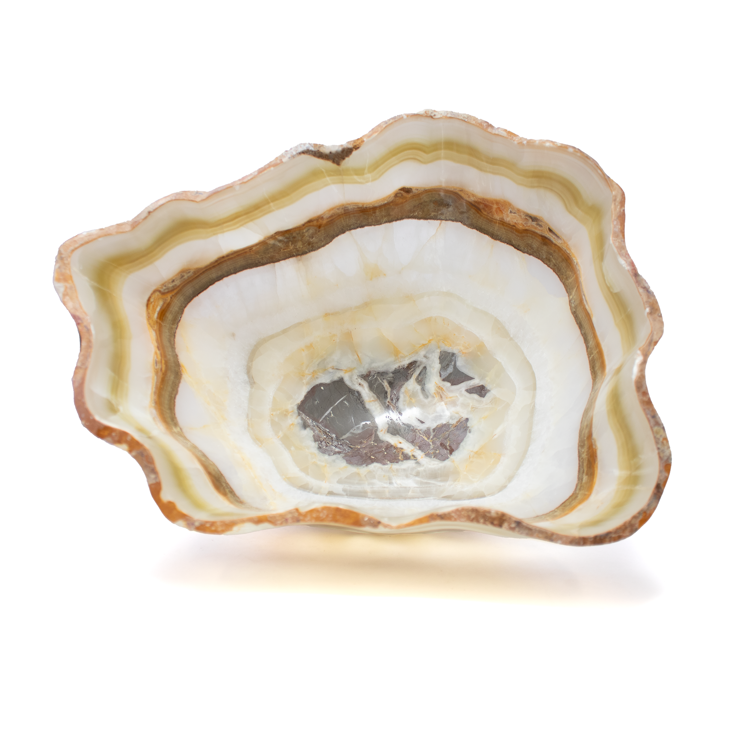 Sculpted from the Earth’s own palette, this Olive Onyx Vessel radiates quiet luxury and grounded elegance. Hand-carved from premium Mexican onyx, it reveals bands of olive green, honeyed cream, and soft sandstone—natural striations etched by time, unique to each piece. Polished to a gentle sheen, its surface catches the light like still water, amplifying the stone’s inner warmth and translucent depth.More than a vessel, it is a statement of presence—equally at home cradling small treasures or standing alone as a sculptural accent. Whether gracing a dining table, mantel, or curated shelf, it brings an organic harmony to modern interiors, a quiet reminder of nature’s timeless artistry. Olive Onyx Vessel