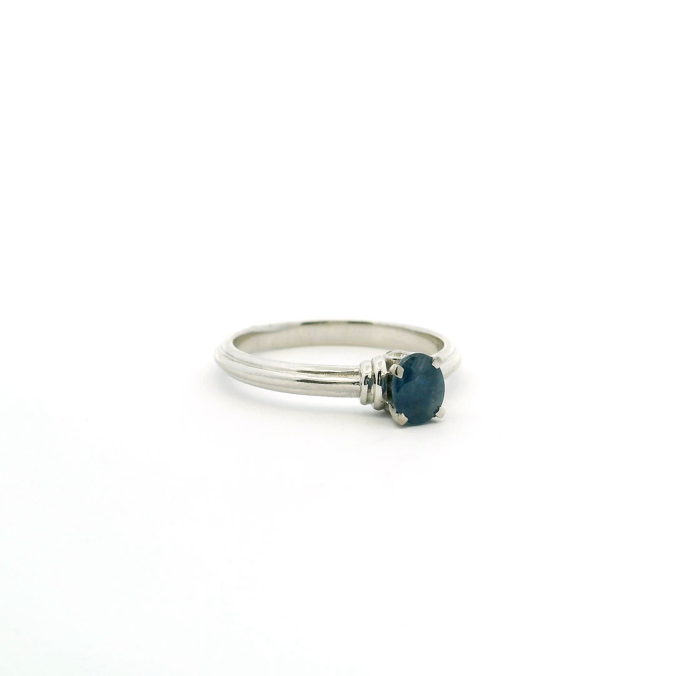 Make a statement with our Faceted Blue Sapphire Ring. A vibrant oval sapphire, expertly faceted for maximum brilliance, is prong-set in sleek 925 sterling silver and flanked by two sparkling white cubic zirconia. The tapered band offers a comfortable, elegant fit for a size 6 finger. Perfect for any occasion, this ring captures timeless beauty and refined craftsmanship in every detail. Faceted Blue Sapphire Ring - Oval Prong Set on 925 Sterling Silver Bezel Set with 2 White CZ Crystals on Tapered Band sz6