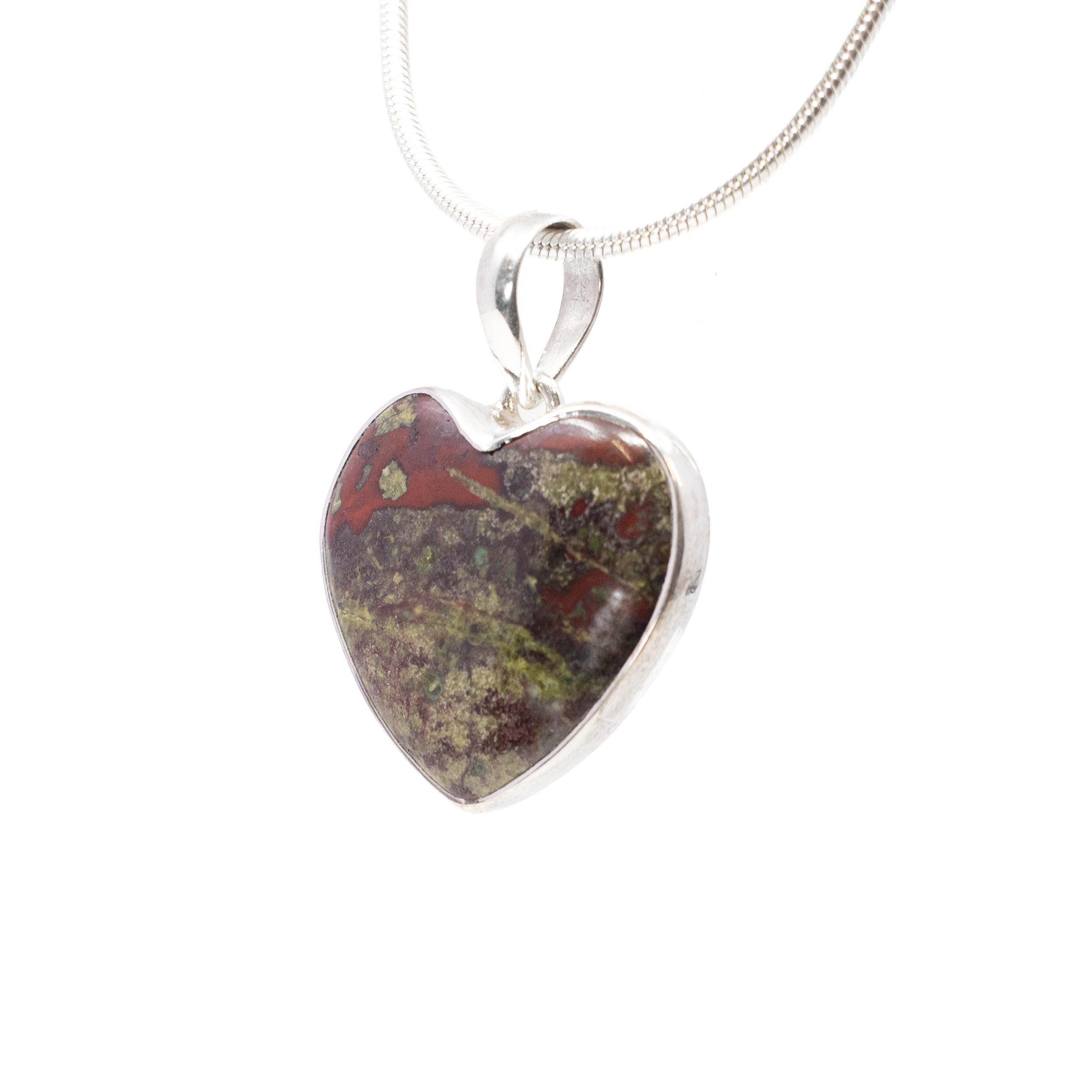 Introducing the Dragon Bloodstone Pendant - a captivating piece that embodies the mystique and allure of ancient legends. This exquisite pendant features a classic heart-shaped cabochon crafted from Dragon Bloodstone, a unique gemstone renowned for its enchanting blend of deep, earthy hues and striking blood-red veining. Each stone is meticulously polished to enhance its natural beauty, making every pendant truly one-of-a-kind.Encasing this magnificent gem is a sleek 925 sterling silver bezel setting, offering a stunning contrast that accentuates the rich colors of the Dragon Bloodstone. The lustrous silver not only provides a secure hold but also adds an elegant touch, making it suitable for both everyday wear and special occasions. Dragon Bloodstone Pendant - Classic Heart Cabochon with 925 Sterling Silver Bezel