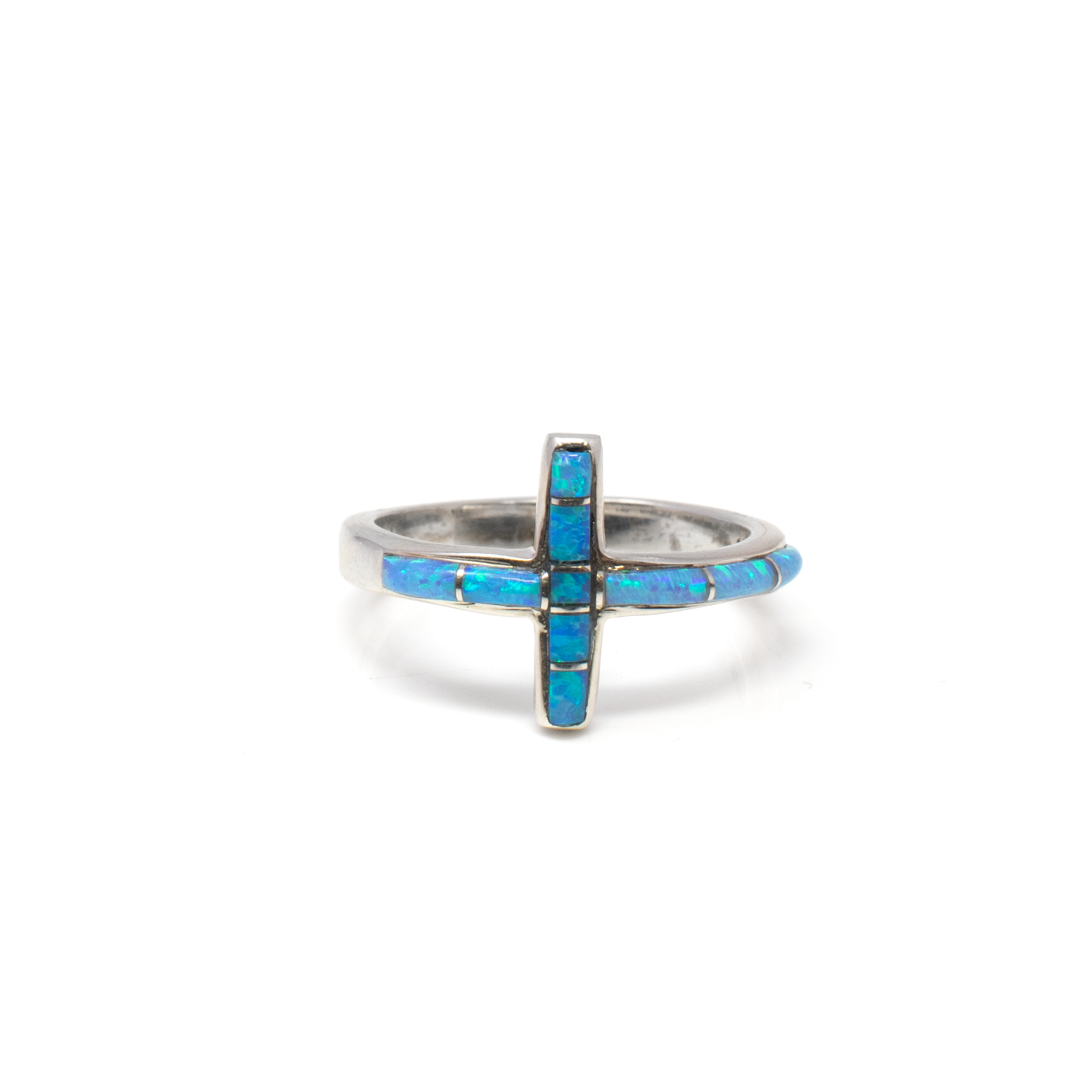 Elevate your jewelry collection with our exquisite Light Blue Opal Inlay Cross Ring, a remarkable piece from Rare Earth Gallery. This stunning ring, designed specifically in size 7, is an embodiment of elegance and spiritual symbolism, making it a cherished addition for any jewelry enthusiast.The focal point of this unique piece is its inlaid design featuring light blue opal, known for its mesmerizing play of colors and soothing hues. This captivating gemstone is artistically crafted in a cross shape, symbolically wrapping around the band. The intricate inlay work highlights the ring's distinct character, ensuring it stands out as a breathtaking accessory.Channeling the vibrant beauty of the blue opal, the ring is crafted from premium 925 sterling silver, renowned for its durability, timeless charm, and hypoallergenic properties. The silver creates a striking contrast with the iridescent opal, enhancing its brilliance and allure. Light Blue Opal Inlay Cross Ring - Wrapping Cross On Band With Silver Channeling Sz7