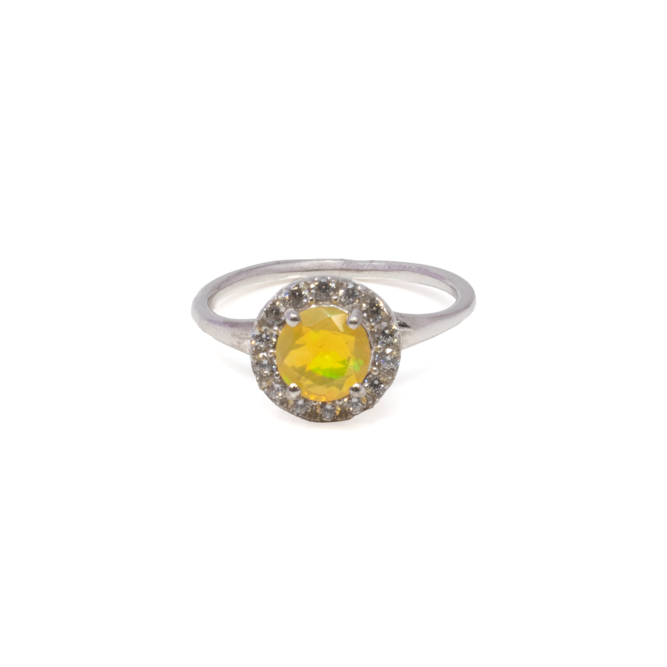 Introducing our exquisite Ethiopian Opal Ring, a true masterpiece for those who appreciate elegance and sophistication in their jewelry collection. This stunning piece showcases a dazzling faceted round Ethiopian opal that captures the play of colors characteristic of this remarkable gemstone. The opal is securely prong-set to highlight its brilliant hues, shimmering with every movement.Crafted from premium 925 sterling silver, the ring exudes a timeless appeal, ensuring durability while maintaining a luxurious look. The band features a delicate crossover design, adding a touch of modern sophistication to the classic setting. Surrounding the opal, a pave edge adorned with sparkling white cubic zirconia stones enhances its captivating beauty, offering a subtle contrast and amplifying the ring's radiance. Ethiopian Opal Ring - Faceted Round Prong Set on 925 Sterling Silver with White CZ Pave Edge & Dainty Cross Over Band sz8