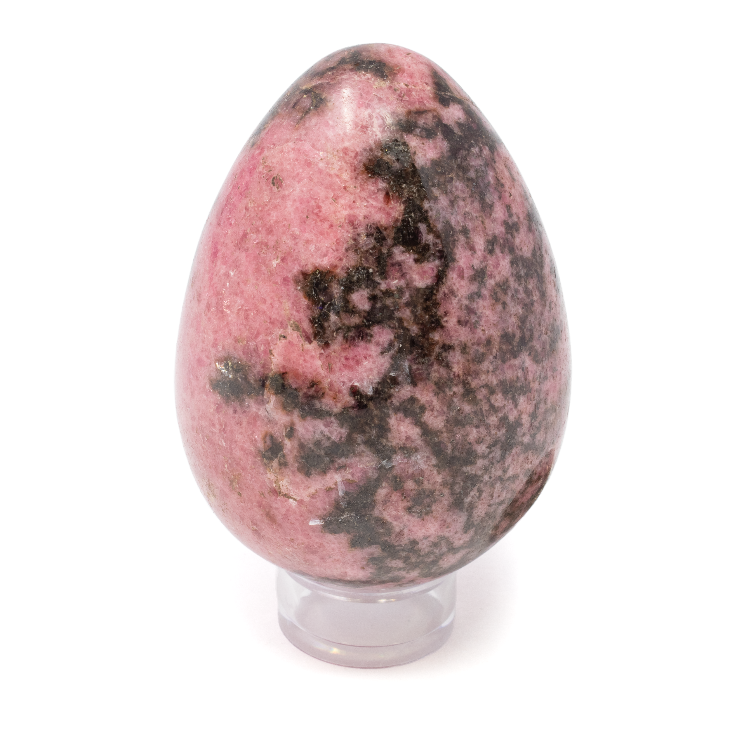 Elevate your collection with the exquisite beauty of our Rhodonite Egg on a Lucite Stand—a stunning piece that seamlessly blends natural artistry with modern elegance. Hailing from the majestic landscapes of Madagascar, this Rhodonite egg is a testament to nature's spectacular craftsmanship.Rhodonite, known for its enchanting pink and deep black hues, is a stone that captivates the eye and warms the soul. Each egg is unique, showcasing intricate patterns and color variations that echo the dynamic processes of the Earth.Beyond its visual appeal, Rhodonite is celebrated for its emotional and spiritual benefits. Often referred to as the "Stone of Love," it is believed to resonate with the heart chakra, promoting compassion, emotional balance, and healing. Rhodonite Egg on Lucite Stand from Madagascar