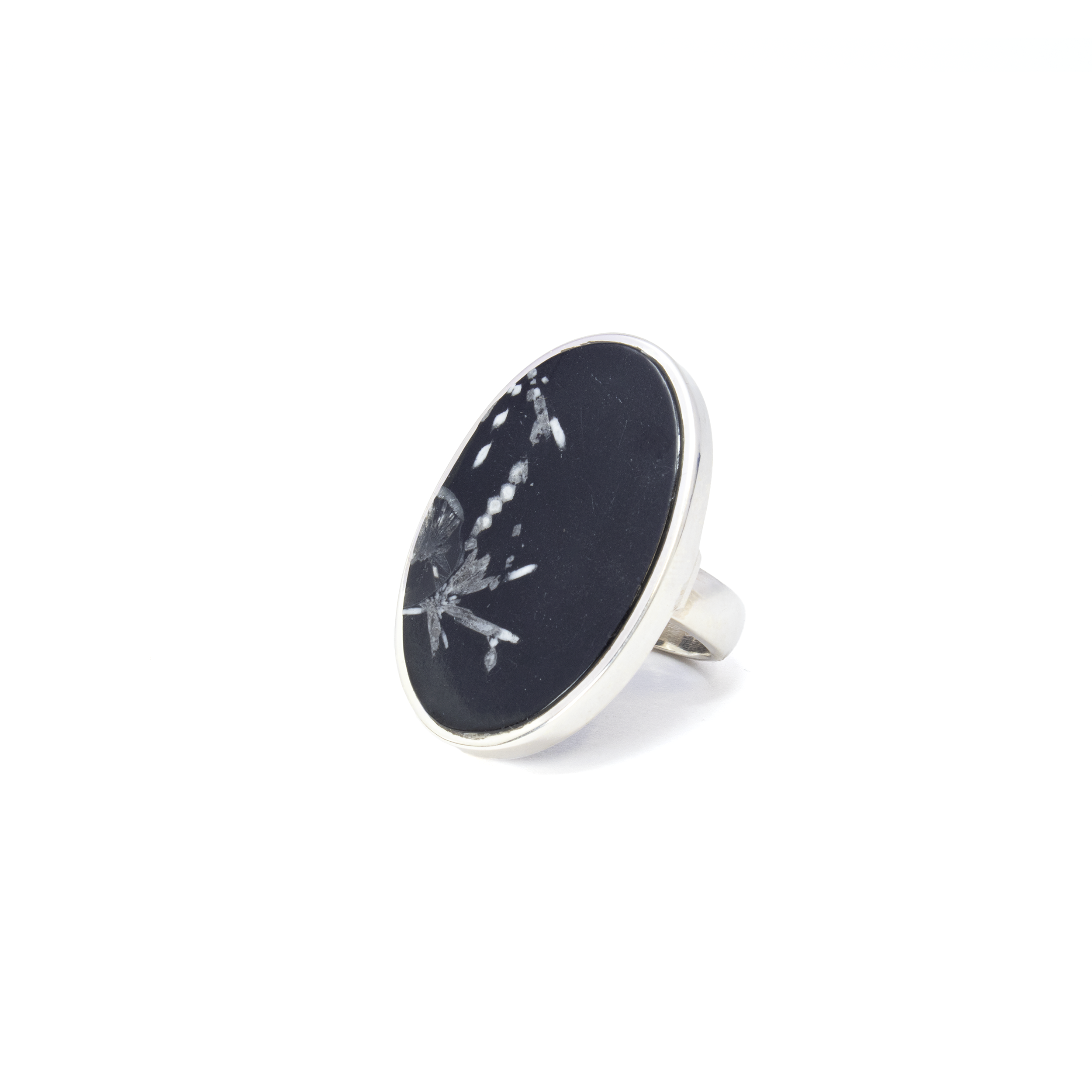 Elevate your jewelry collection with our exquisite Chrysanthemum Stone Ring, meticulously crafted for those who appreciate timeless elegance and natural beauty. This stunning piece features a classic flat-cut oval chrysanthemum stone, renowned for its unique floral pattern that appears like a beautiful chrysanthemum bloom frozen in time. The stone's intricate design is perfectly complemented by a luxurious 925 sterling silver bezel setting, ensuring that this ring stands as a true testament to fine craftsmanship.The band, also made of high-quality 925 sterling silver, offers durability and a lustrous finish that enhances the natural beauty of the stone. Designed with versatility in mind, this ring is a size 8 but comes with an adjustable band, allowing you to comfortably fit it to your preferred size. Whether it’s a gift for a loved one or a treat for yourself, this piece adapts effortlessly to any finger and occasion. Chrysanthemum Stone Ring - Classic Flat Cut Oval with 925 Sterling Silver Bezel & Band sz8-ADJ