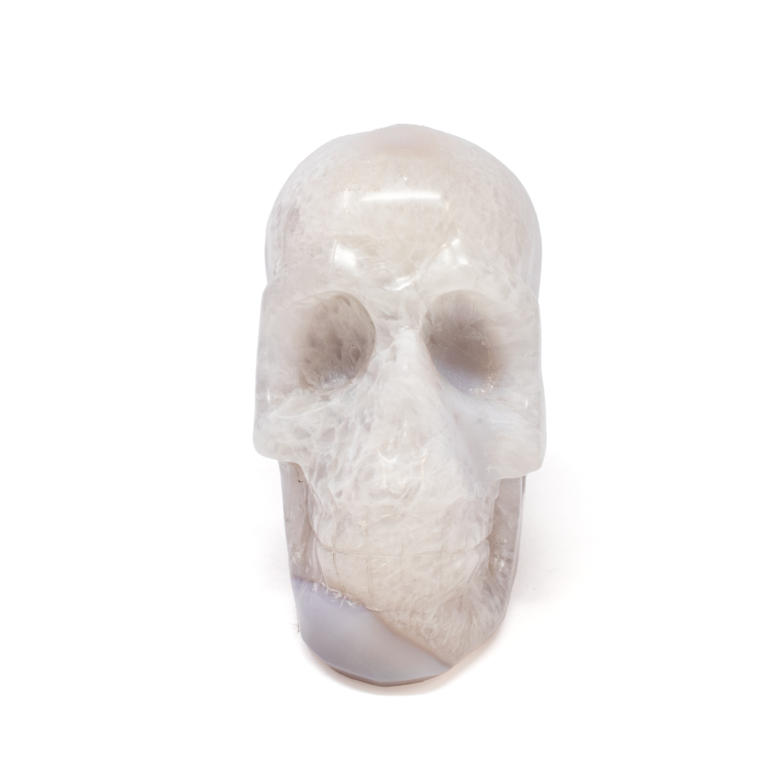 Discover the remarkable blend of natural wonder and artisanal craftsmanship with our Agate Geode Skull Carving, featuring a mesmerizing Periwinkle Blue Druze Pocket. This unique sculpture is more than a decorative piece; it’s a stunning conversation starter and an extraordinary work of art that captivates the imagination.Meticulously carved from high-quality agate geode, this skull showcases the intricate patterns and rich textures that agate is renowned for, offering a one-of-a-kind aesthetic that is both striking and serene. Central to this sculpture is a breathtaking periwinkle blue druze pocket. The sparkling crystals create a vivid contrast against the smooth surface of the agate, adding depth and a sense of mystery to the piece. Agate Geode Skull Carving with Periwinkle Blue Druze Pocket