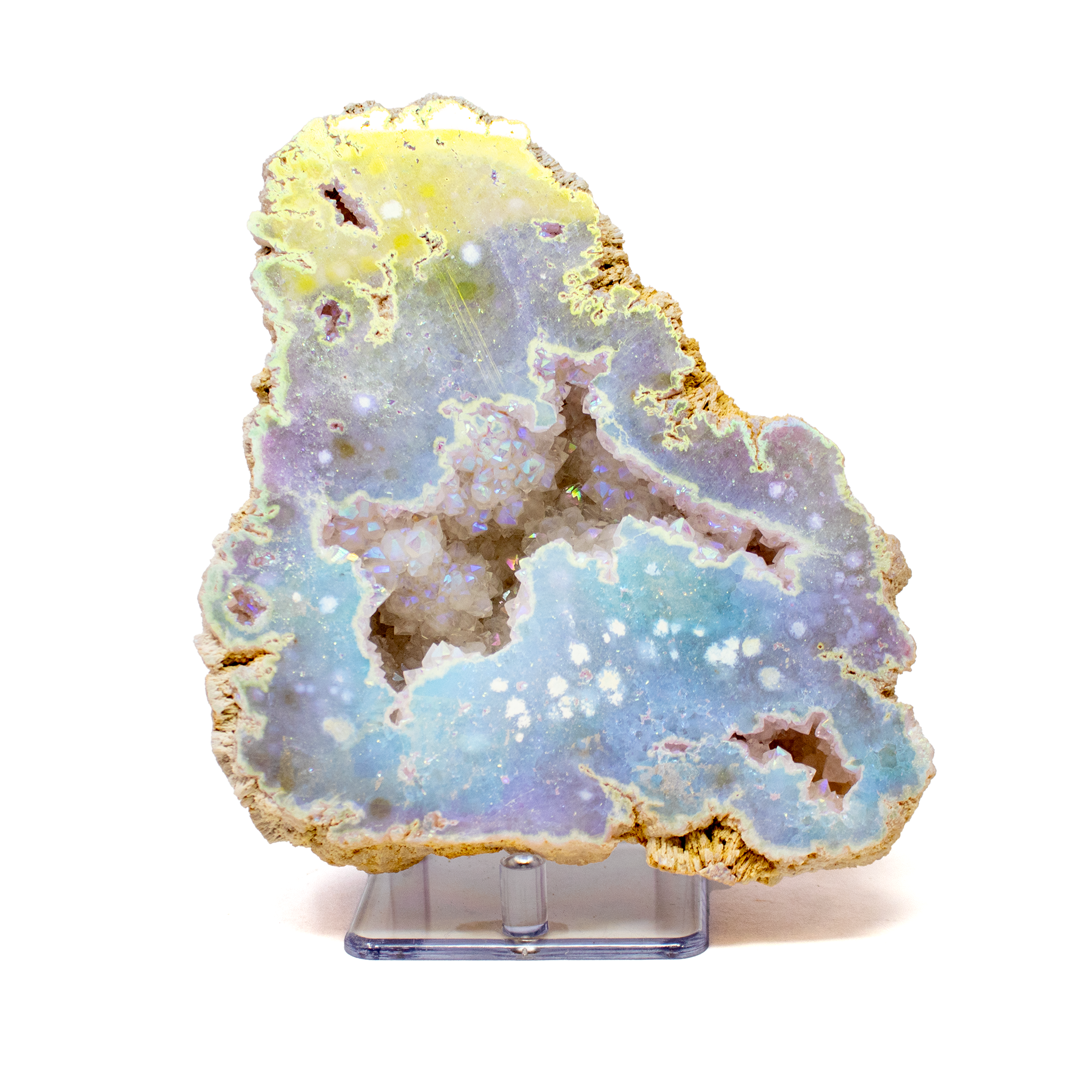 Add a touch of ethereal elegance to your space with this Silicon Oxide Geode, featuring a beautifully cut face that reveals a shimmering crystal interior. Treated with an Angel Aura finish, the geode sparkles with iridescent hues that shift and dance in the light, creating a mesmerizing display. Set on a minimalist Lucite stand, the piece appears to float—offering a modern, airy presentation that lets the natural beauty take center stage.Perfect for collectors and design lovers alike, this geode is both a striking decorative accent and a celebration of nature’s hidden wonders. Whether showcased on a shelf, desk, or altar, it brings radiant energy and timeless charm to any environment. Silicon Oxide Geode With Cut Face On Lucite Stand