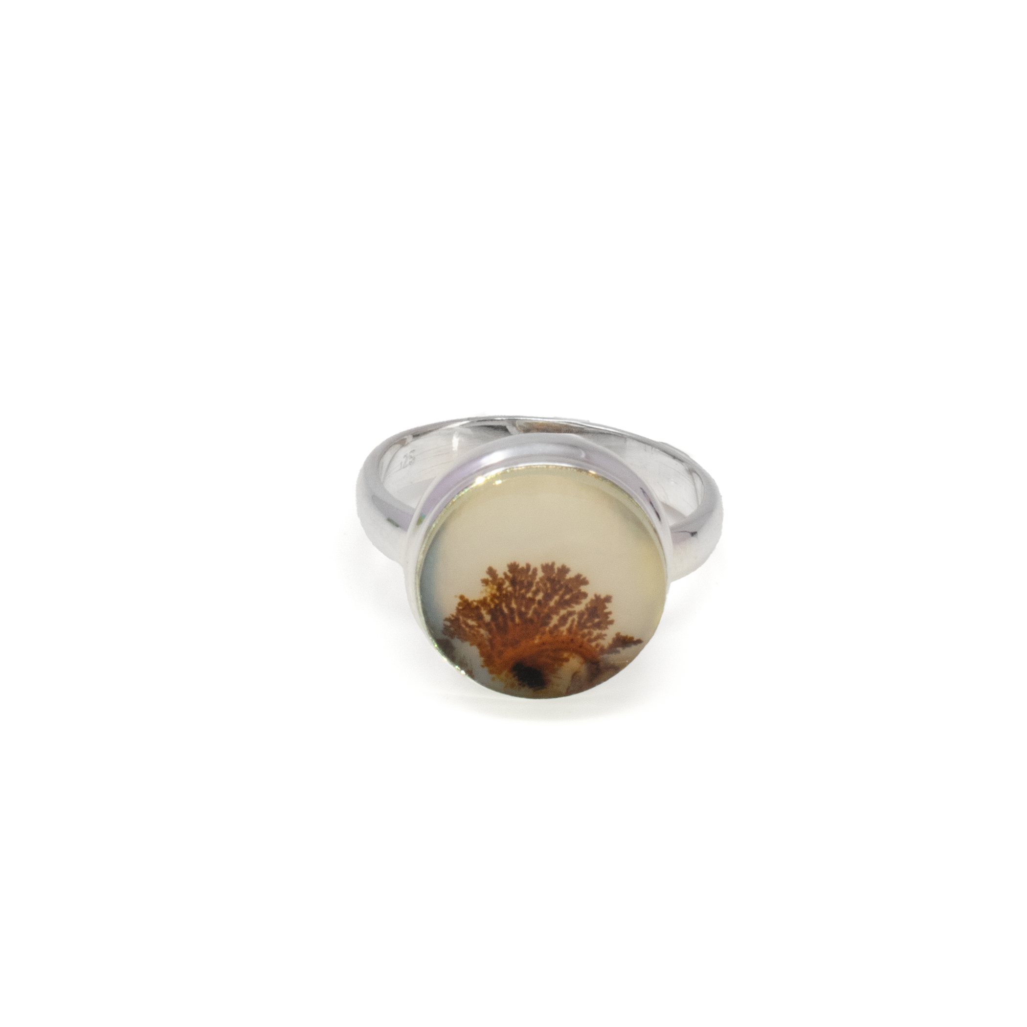 The Dendritic Agate Ring showcases the enchanting beauty of nature captured in a sleek and elegant design. Centered in a simple yet sophisticated round bezel setting, the dendritic agate stone exudes unique, intricate patterns reminiscent of delicate tree branches, symbolizing growth and harmony. The stone's natural allure is beautifully complemented by the high-quality 925 sterling silver band, offering both durability and timeless appeal.Crafted to perfection, this ring is available in size 8 and serves as a versatile piece that seamlessly blends with any jewelry collection. Its understated elegance makes it ideal for everyday wear, while the distinctiveness of the dendritic agate adds a touch of rarity to special occasions. Whether worn alone or stacked with other rings, this dendritic agate piece is a testament to fine craftsmanship and the splendor of nature. Embrace the serene beauty and carry a piece of earth’s art with you wherever you go. Dendritic Agate Ring - Round Simple Bezel set in 925 Sterling Silver Size 8