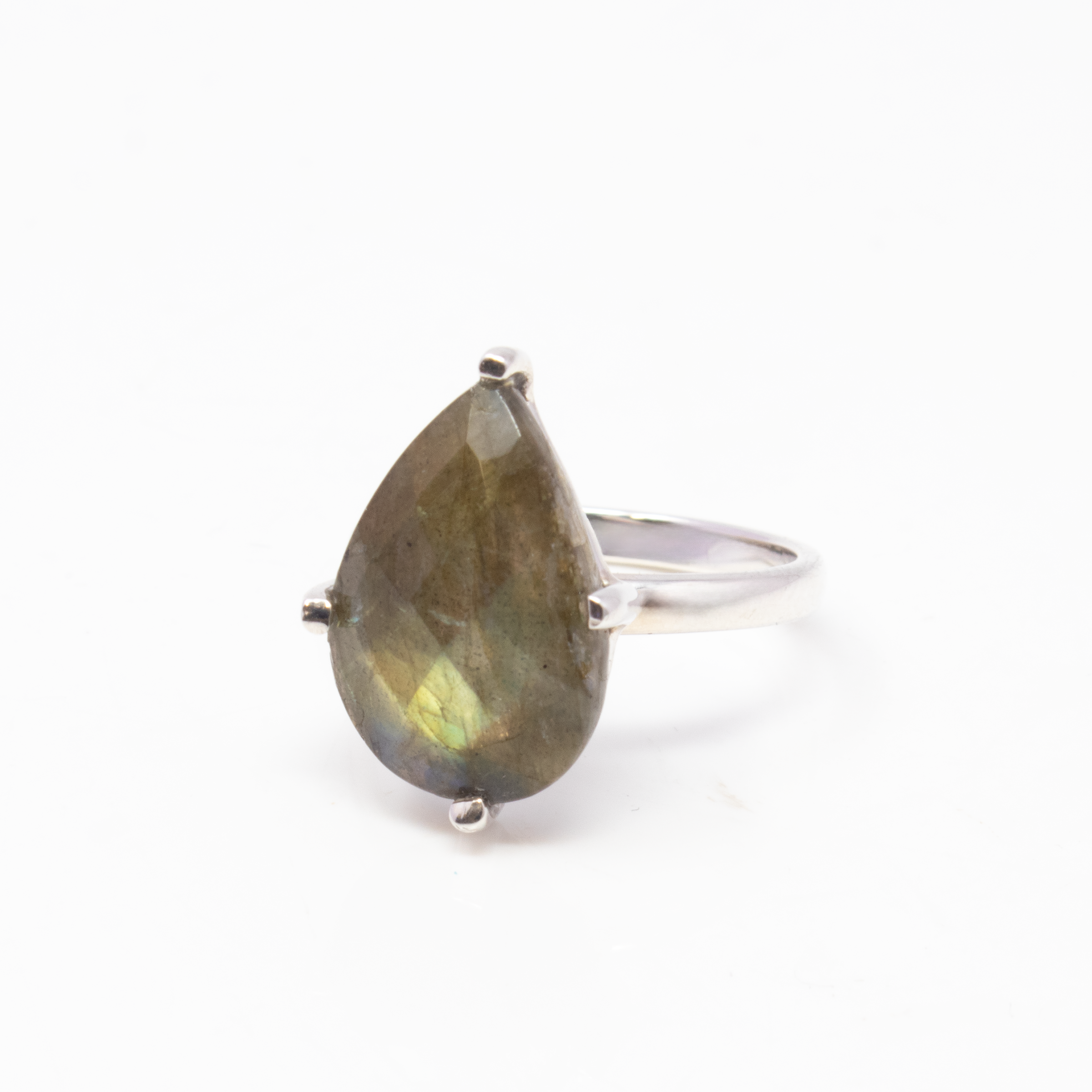 Introducing the captivating Faceted Labradorite Ring, a timeless piece that effortlessly combines elegance and mystique. This striking ring features a stunning pear-shaped labradorite gemstone, expertly faceted to enhance its natural iridescence. The stone is securely prong-set, allowing light to pass through and illuminate its captivating play of colors, from shimmering blues to vibrant greens, creating a mesmerizing visual effect with every move.Crafted with care, this ring is set on a simple yet sophisticated 925 sterling silver band. The sleek design of the band perfectly complements the stone, making it an ideal accessory for any occasion, whether you're dressing up for a night out or adding a touch of elegance to your everyday ensemble. Faceted Labradorite Ring - Prong Set Pear Set on Simple 925 Sterling Silver Band sz6