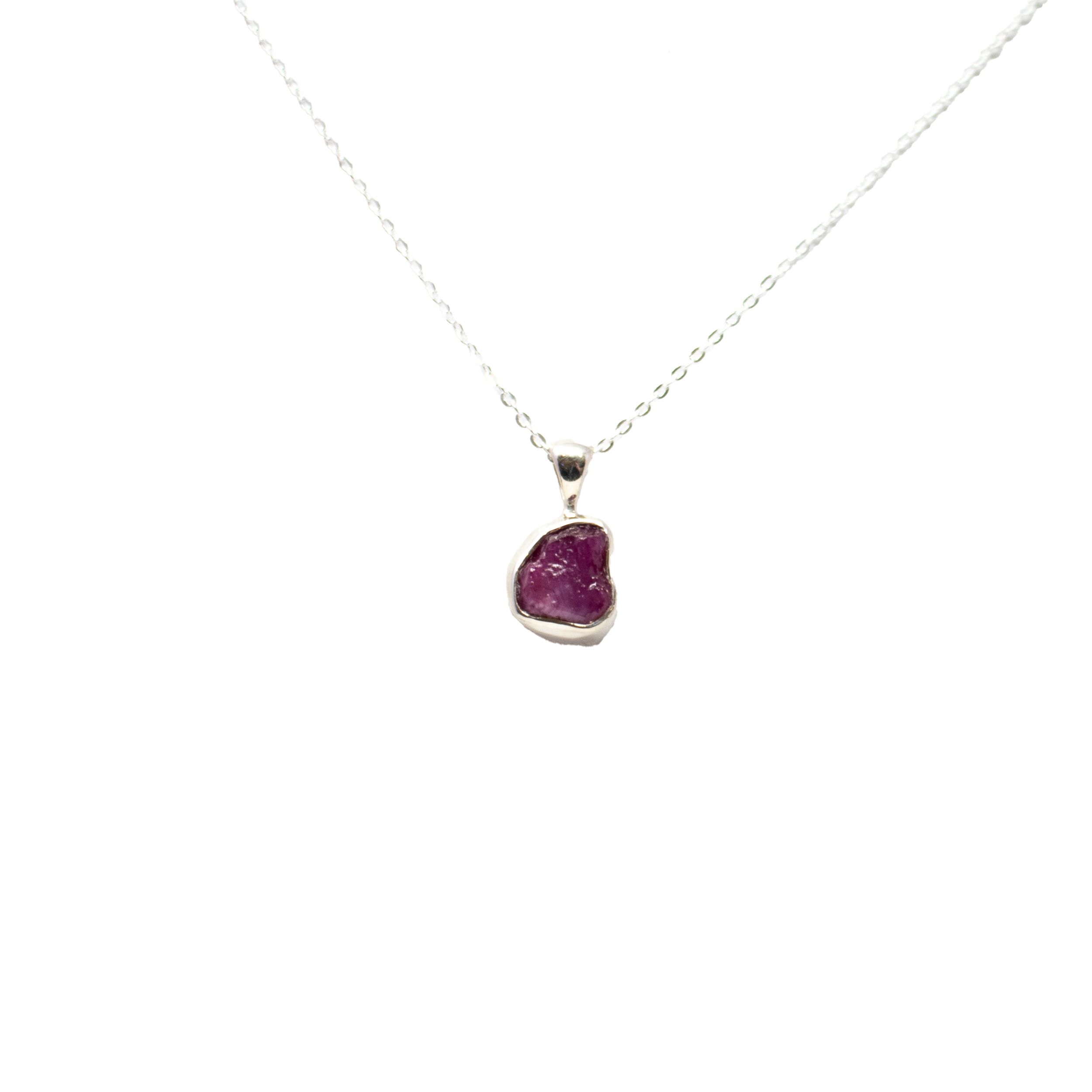 Illuminate your style with our Ruby Necklace, featuring a mesmerizing rough freeform ruby set in a sleek 925 sterling silver bezel. Suspended from an elegant 18-inch chain, this women's necklace celebrates the natural allure of uncut gemstones, making each piece wonderfully unique. The vibrant crimson hues of the ruby radiate passion and confidence, while the minimalist sterling silver setting adds contemporary sophistication. Perfect for everyday elegance or as a striking statement piece, this necklace is a timeless addition to any jewelry collection – and a thoughtful gift for the one you cherish. Ruby Necklace - Rough Freeform with 925 Sterling Silver Bezel & 18" Chain