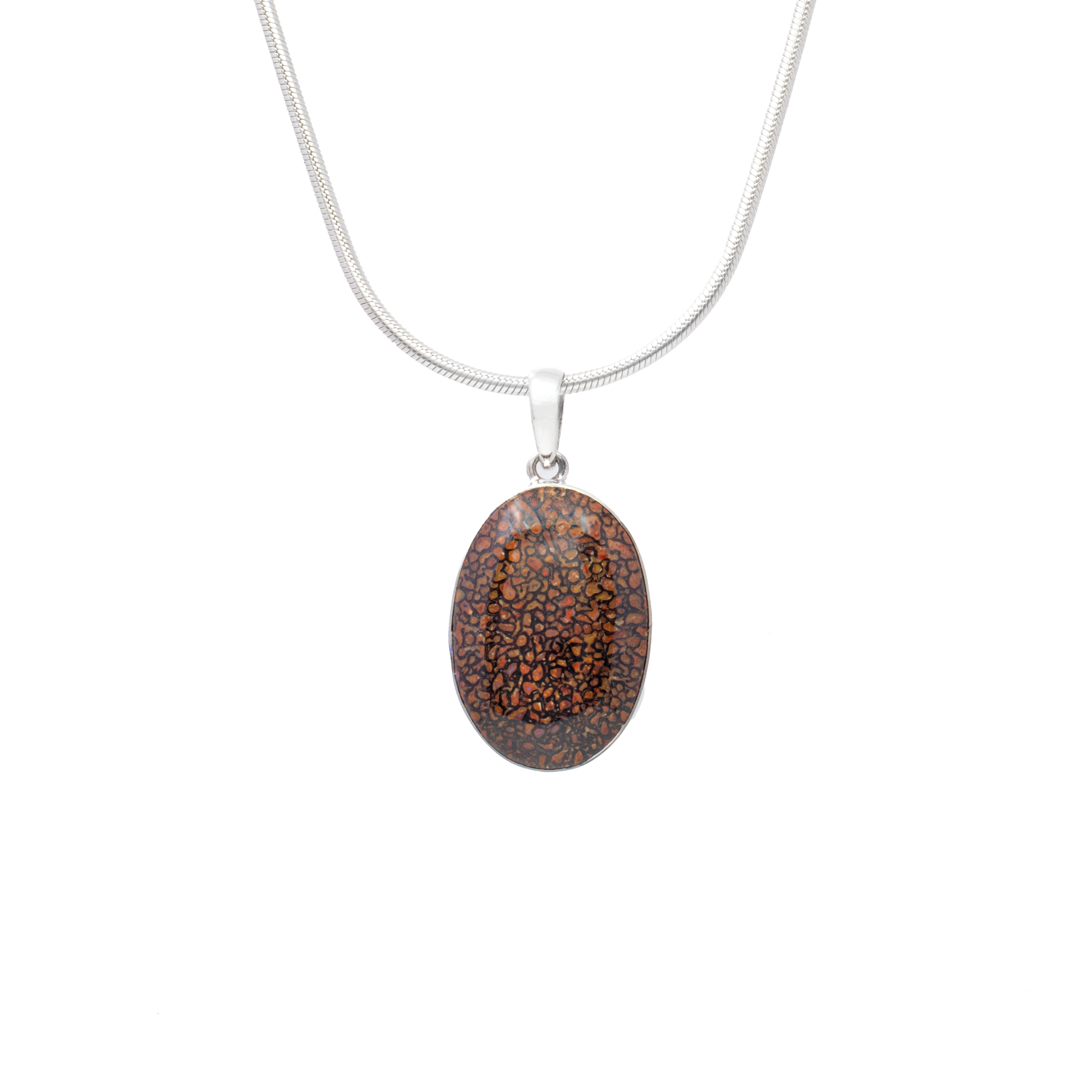 Unearth the allure of natural history with our Dinosaur Bone Fossil Pendant, a timeless masterpiece that seamlessly blends ancient elegance with modern craftsmanship. This captivating pendant features an oval cabochon meticulously crafted from genuine dinosaur bone fossil, offering a unique glimpse into the prehistoric past.Encased in a luxurious 925 sterling silver bezel, this pendant exudes sophistication and charm, making it a perfect addition to any jewelry collection. The sterling silver setting enhances the fossil's natural beauty, adding a touch of elegance while ensuring durability and lasting shine.Each fossil cabochon presents its own distinctive pattern and color variations, making every piece truly one-of-a-kind. The organic earth tones and intricate textures are a work of art, perfect for the woman who appreciates history, nature, and individuality in her accessories. Dinosaur Bone Fossil Pendant - Oval Cabochon with 925 Sterling Silver Bezel