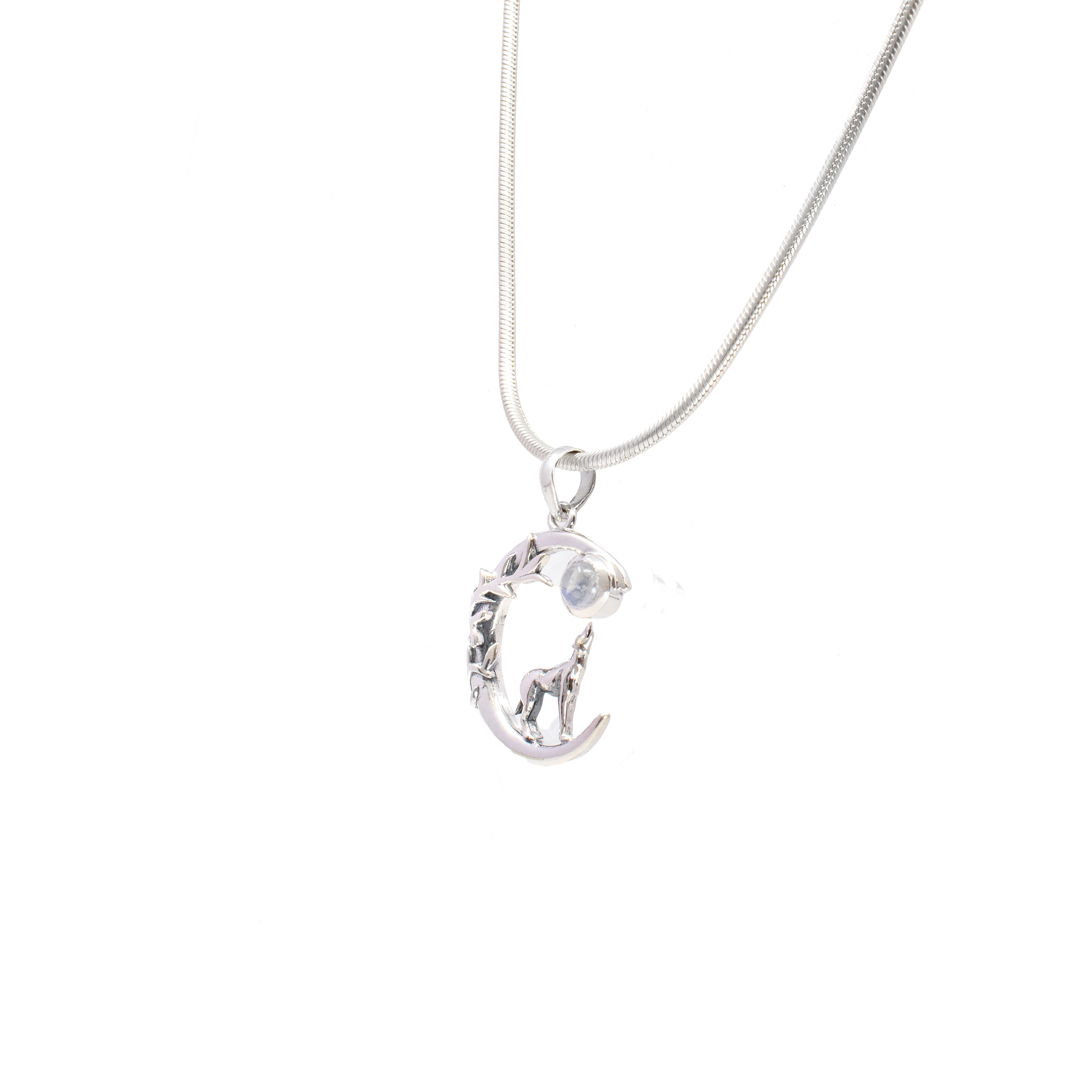 Unleash the mystic allure of the moon with our exquisitely crafted Rainbow Moonstone Pendant. This captivating piece features a mesmerizing round cabochon cut of genuine Rainbow Moonstone set against a backdrop of lustrous 925 sterling silver, intricately designed to emulate a celestial moon adorned with delicate vines. At its pinnacle, a howling wolf stands in reverence, embodying spirit and strength.The enchanting Rainbow Moonstone, known for its iridescent glow that dances with every angle, evokes the ethereal beauty of the night sky.A round cabochon cut enhances the stone’s natural luminescence, set within a meticulously crafted silver moon embellished with elegant, flowing vines. The howling wolf adds an element of wild beauty and resilience. Rainbow Moonstone Pendant - Round Cabochon Set on 925 Sterling Silver Moon with Vines & Howling Wolf