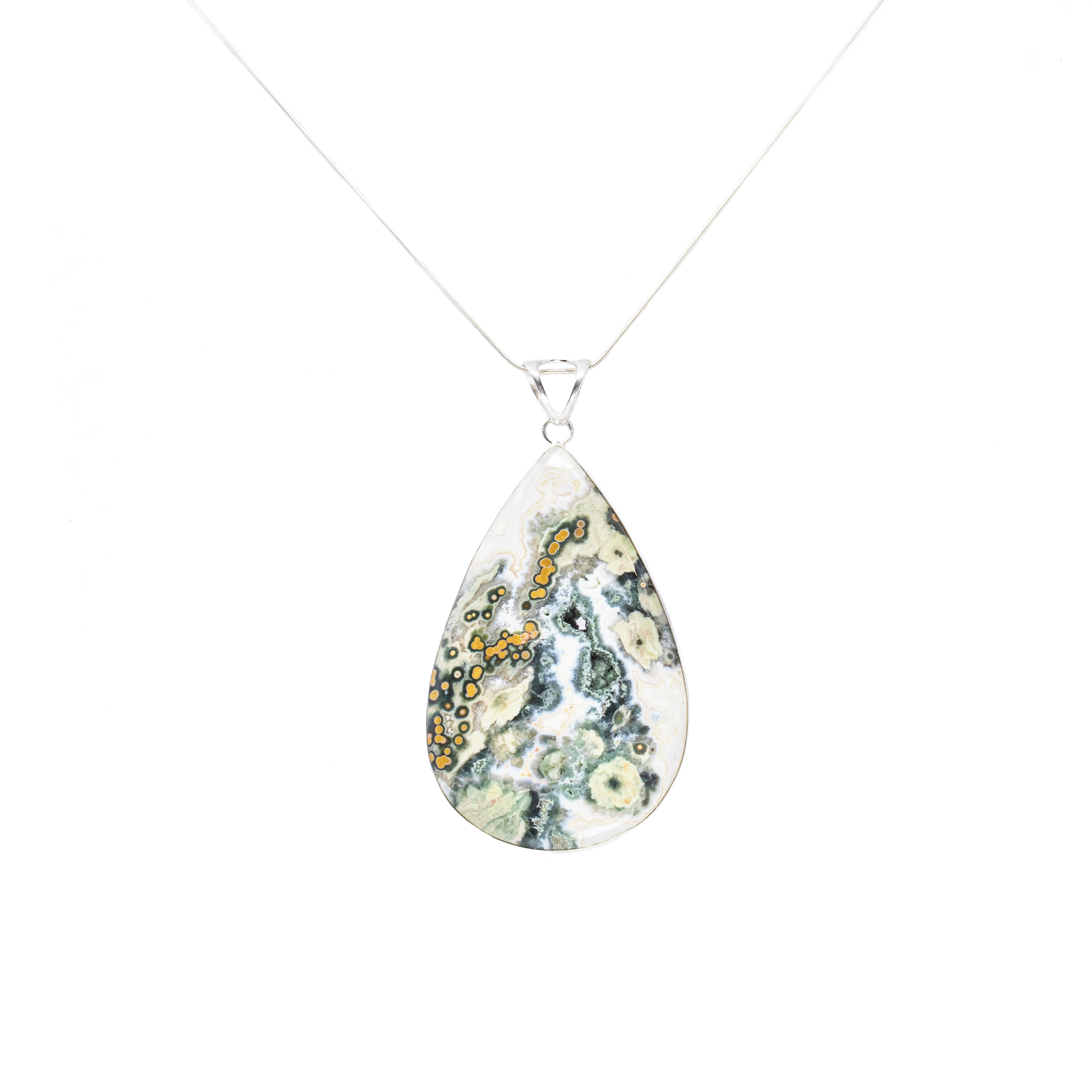 Introducing our exquisite Ocean Jasper Pendant, a stunning piece of jewelry that beautifully captures the essence of nature. This large pear cabochon pendant features a mesmerizing blend of dark green and white hues, adorned with ochre orbicular patterns and delicate sage flower bursts, reminiscent of serene ocean waves and coastal flora.Encased in a simple yet elegant 925 sterling silver bezel, this pendant exudes sophistication and timeless charm. The high-quality sterling silver setting not only enhances the pendant's natural beauty but also ensures durability and longevity, making it a cherished addition to any jewelry collection. Ocean Jasper Pendant - Large Pear Cabochon with Simple 925 Sterling Silver Bezel - Dark Green & White Hues with Ochre Orbiculars & Sage Flower Bursts 3"+
