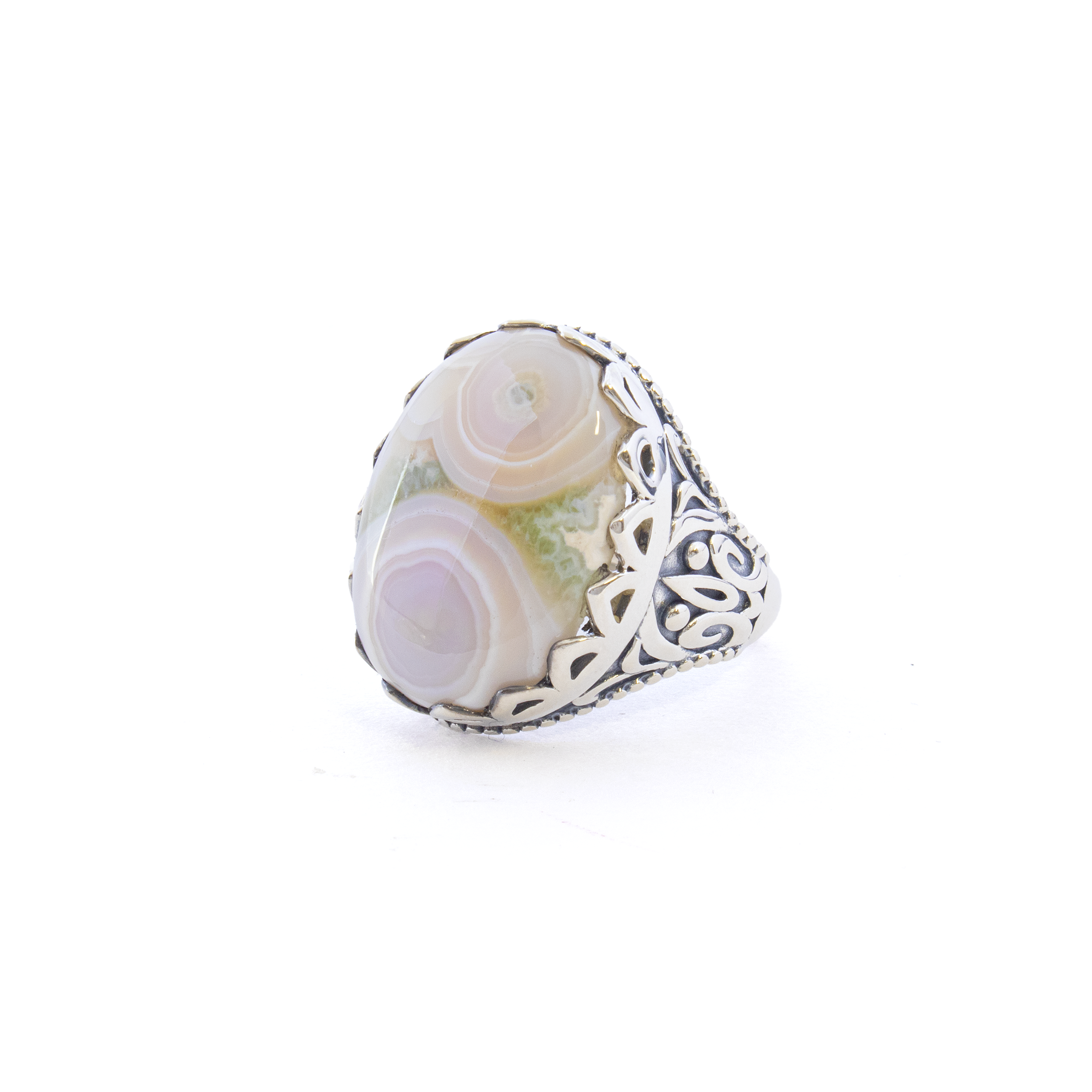 Introducing the Ocean Jasper Ring, a timeless piece that encapsulates the serene beauty of the sea within a stunning, classic design. This exquisite ring features an eye-catching oval cabochon of natural Ocean Jasper, renowned for its mesmerizing swirls of greens, blues, and earth tones that evoke the tranquil essence of oceanic wonders.Encased in a sophisticated 925 sterling silver bezel, the gem is beautifully highlighted by a scalloped edge, adding a touch of elegance and refinement. The beautifully crafted band showcases an intricate Fleur de Lis design, an emblem of regal sophistication and subtle elegance, making this ring not just an accessory, but a statement piece. Ocean Jasper Ring - Classic Oval Cabochon Set in Elegant 925 Sterling Silver Bezel with Scalloped Edge & Fleur de Lis Design on Band sz6