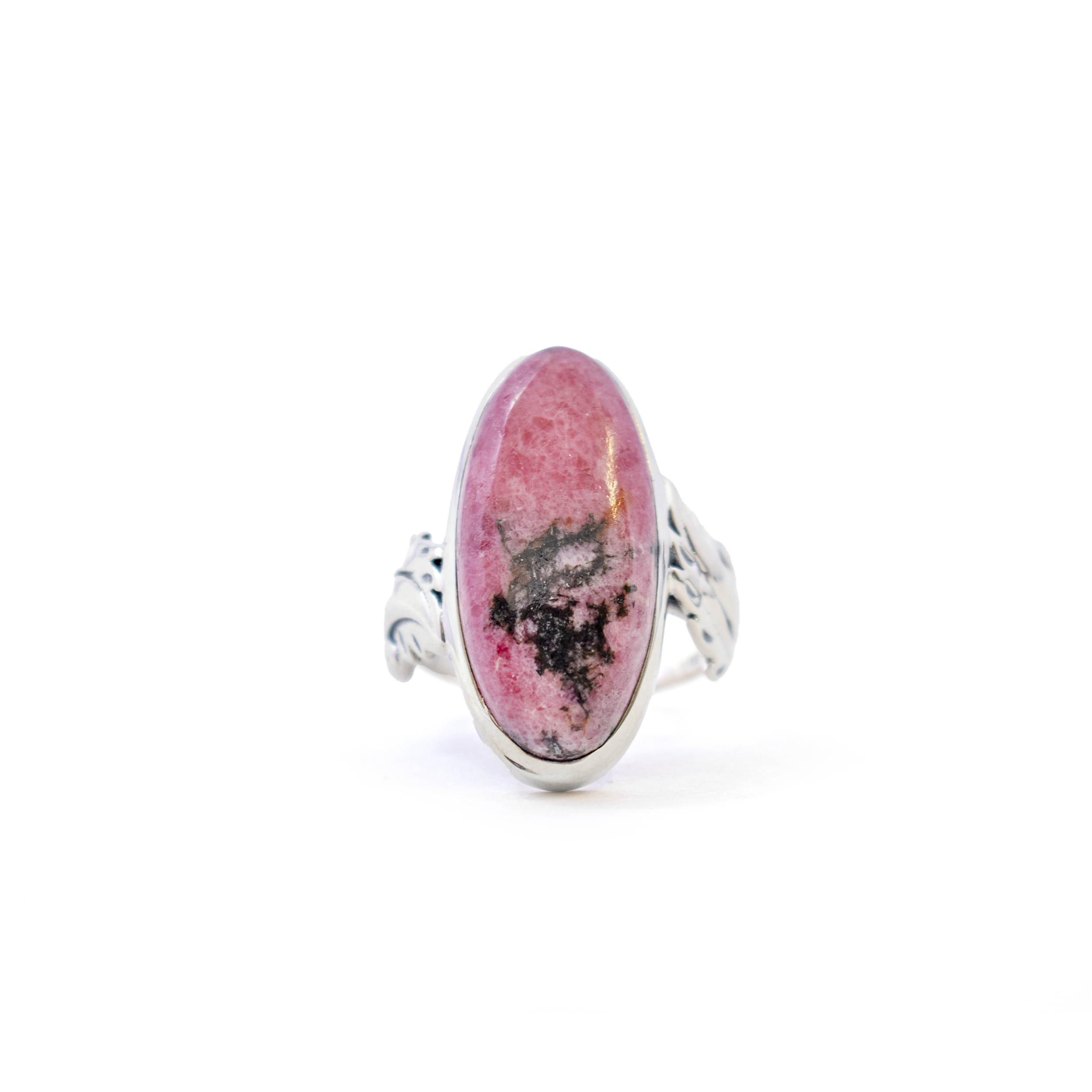 Introducing our exquisite Rhodonite Ring, a stunning piece that effortlessly combines elegance and earthy charm. This meticulously crafted ring features an elongated oval cabochon of alluring rhodonite, renowned for its beautiful pink hue interspersed with striking black veins. Encased in a lustrous 925 sterling silver bezel, the rhodonite gemstone is the centerpiece of this captivating design. The sterling silver not only enhances the stone's natural beauty but also ensures durability and a timeless appeal, making it a perfect accessory for any occasion. Rhodonite Ring - Elongated Oval Cabochon with 925 Sterling Silver Bezel & Feather Stamped Band sz8