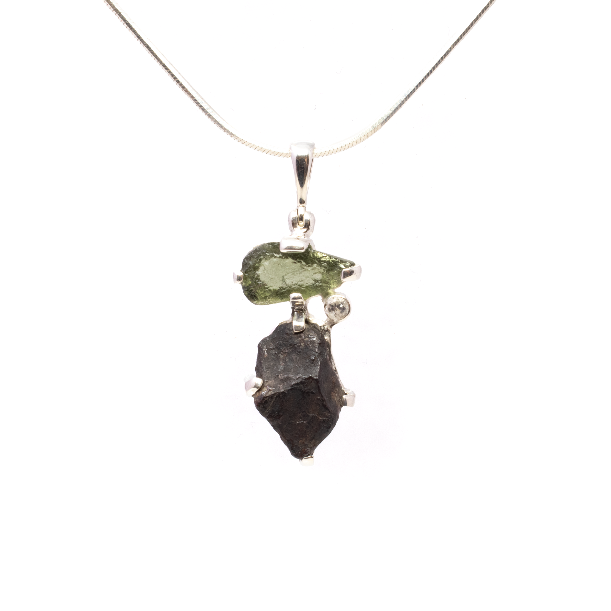 Unveil the beauty of the cosmos with our Agoudal Meteorite Pendant. Featuring a rugged Agoudal Meteorite fragment paired with vibrant green Moldavite and a sparkling bezel-set white topaz, this pendant blends celestial mystery with earthly elegance. Crafted for women who appreciate rare, meaningful jewelry, it’s a striking symbol of endurance, transformation, and timeless beauty. Agoudal Meteorite Pendant - Rough Speciman Prong Set with Moldavite & Faceted Dainty White Topaz Round Bezel Set in 925 Sterling Silver