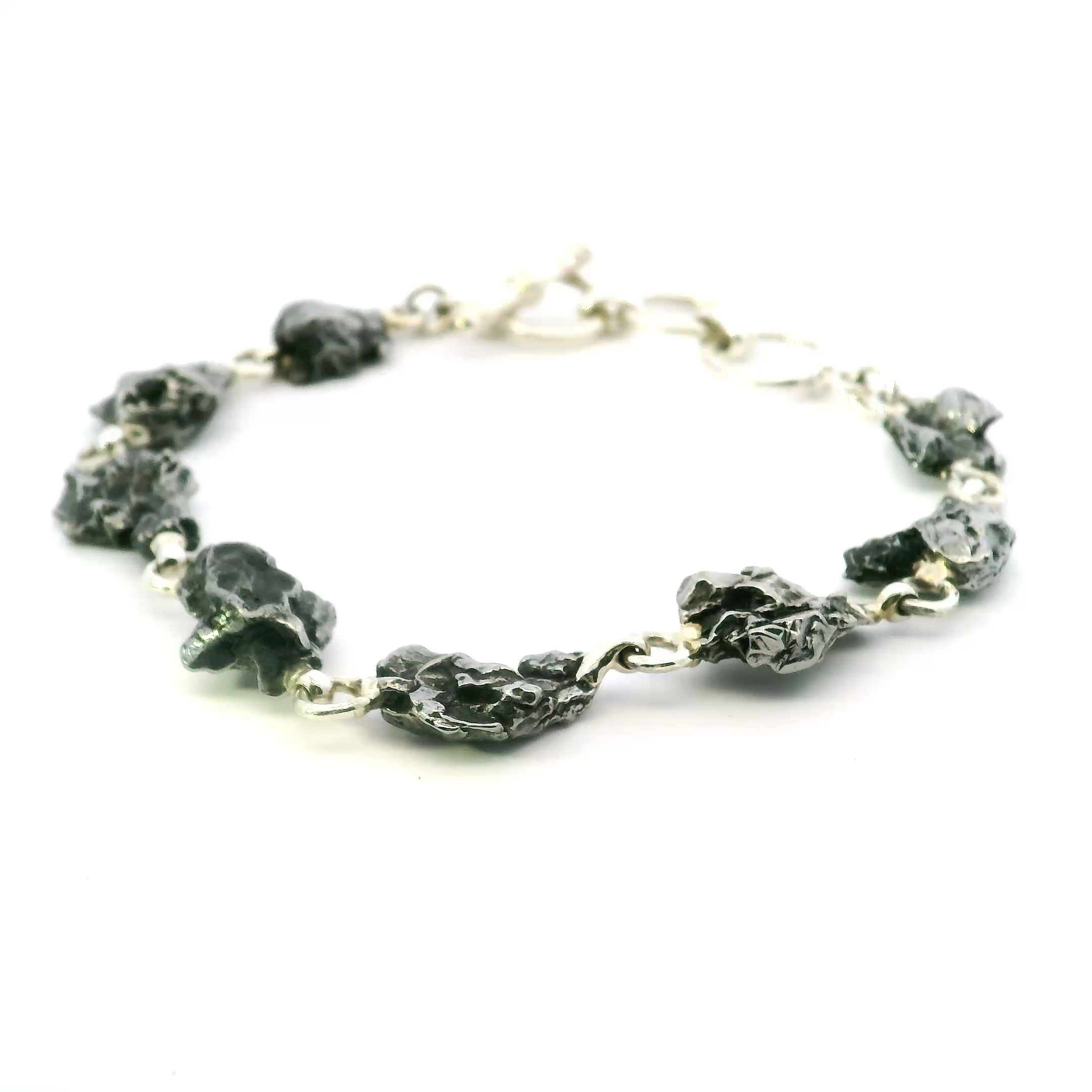 Add a touch of the cosmos to your style with our Meteorite Link Bracelet. Each link features a genuine meteorite fragment, making every piece truly one-of-a-kind.Crafted with durable, high-quality metals and an adjustable clasp for the perfect fit, this bracelet blends celestial texture with modern elegance.Whether worn solo or layered, it’s a bold statement and a subtle nod to the wonders of the universe. Campo De Cielo Meteorite Link Bracelet - 8 Simple Freeforms Set with Attached Jump Rings in 925 Sterling Silver