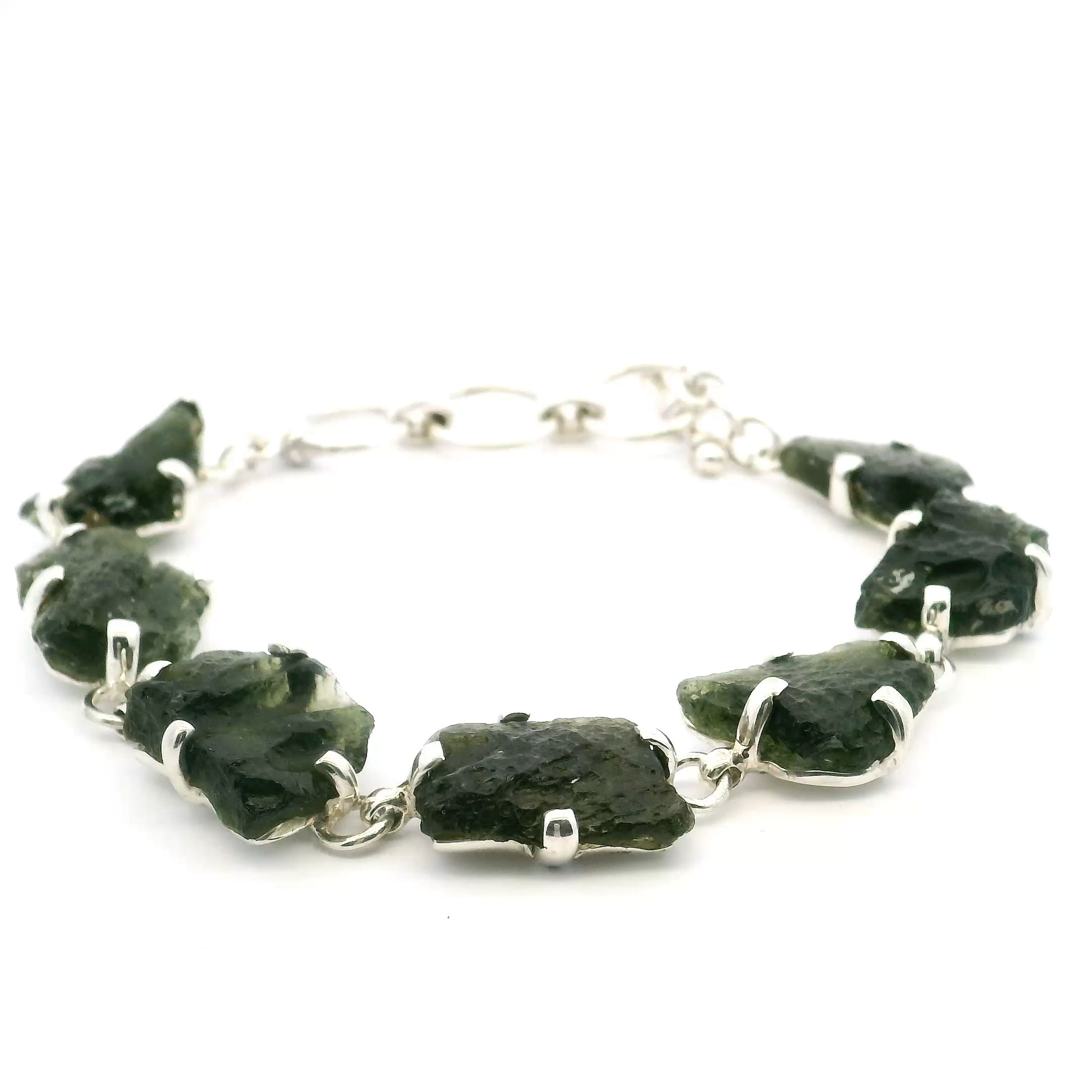 Experience the magic of the cosmos with our Moldavite Link Bracelet, featuring the rare and captivating Moldavite stone. Formed from a meteorite impact, Moldavite is treasured for its deep green color, unique origin, and powerful energy.Each bracelet is crafted with polished Moldavite stones, linked in silver or gold to create a graceful, elegant design. Perfect for both everyday wear and special occasions, it adds a bold, meaningful touch to any outfit.Known for its ties to transformation and spiritual growth, Moldavite brings a deeper connection to the universe—making this bracelet not just beautiful, but truly inspiring. Moldavite Link Bracelet - 7 Nuggets Prong Set in 925 Sterling Silver with Toggle Clasp