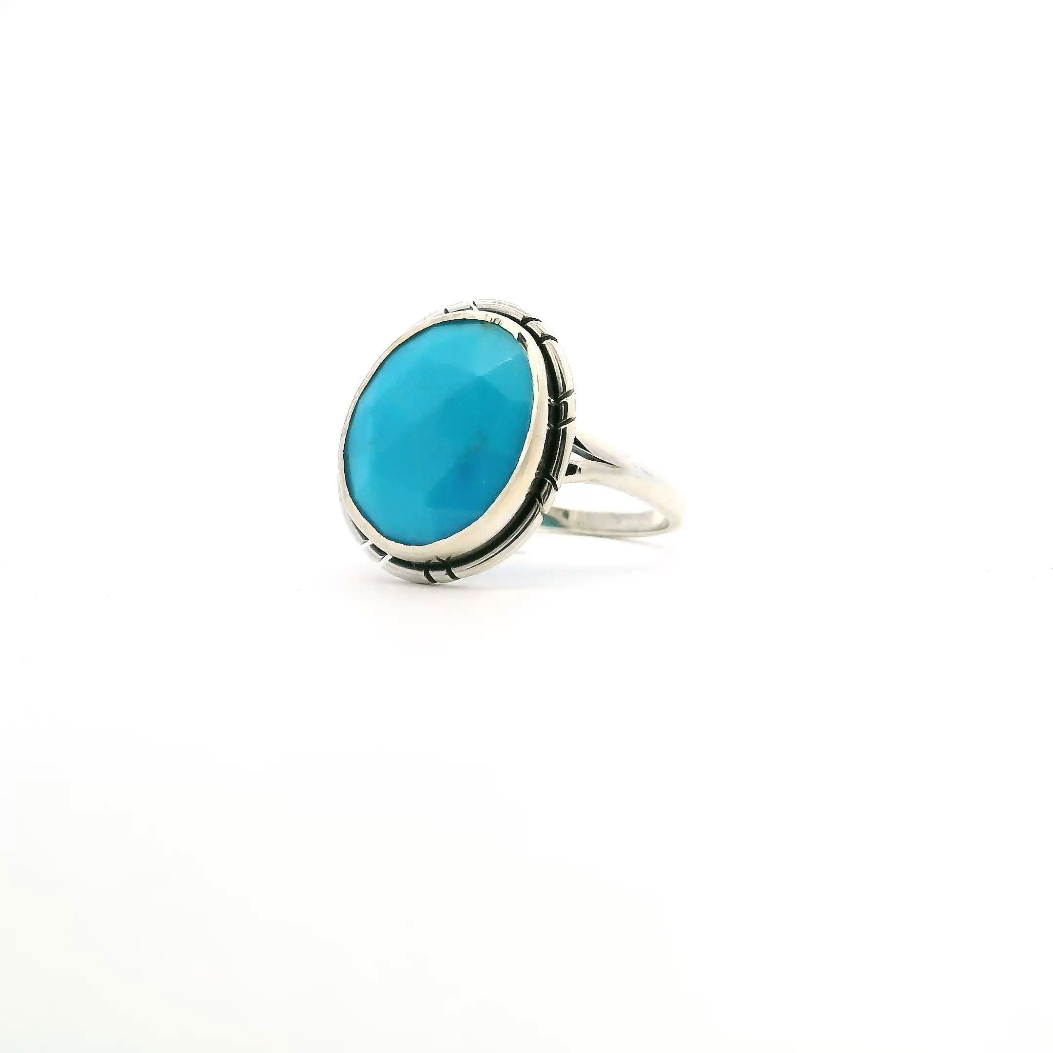 This size 7 ring features a vibrant faceted round turquoise stone from New Mexico, bezel set in polished 925 sterling silver. Intricate stamped line details frame the stone, adding a handcrafted touch rooted in Southwestern tradition.Finished with a double band for added style and comfort, this ring blends timeless elegance with cultural significance—perfect for everyday wear or as a meaningful statement piece. New Mexican Turquoise Ring - Faceted Round Bezel Set with Stamped Line Detail & Double Band in 925 Sterling Silver sz7
