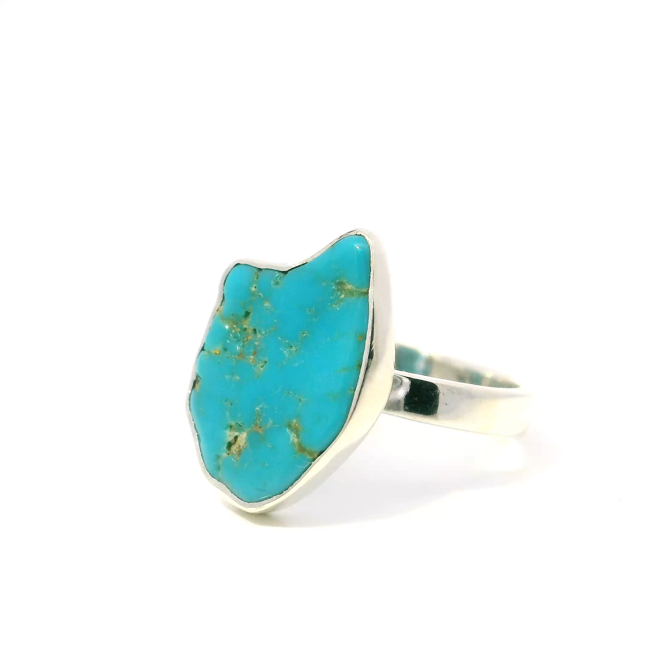 The New Mexican Turquoise Ring showcases a polished freeform turquoise stone carved into a whimsical cat face, each piece bearing a unique matrix and vibrant hues that make it truly one-of-a-kind. Set in a sleek, minimalist 925 sterling silver bezel, the design highlights the stone’s natural beauty with elegant simplicity.Crafted for comfort and style, this size 9 ring combines Southwestern charm with playful artistry. Its durable sterling silver setting and distinctive turquoise make it perfect for everyday wear or special occasions, appealing to lovers of unique statement jewelry and cat-inspired designs alike. New Mexican Turquoise Ring - Polished Freeform Cat Face Bezel Set in Simple 925 Sterling Silver sz9