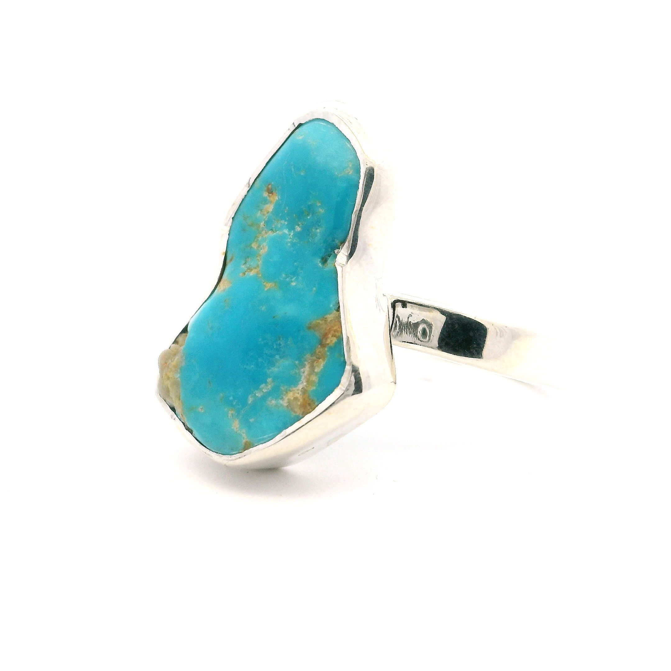 This handcrafted ring features a vibrant New Mexican turquoise stone with stunning natural marbling, polished to reveal rich blues and greens. Set in a two-tone freeform bezel, it combines rustic charm with modern sophistication.Finished with a 925 sterling silver band, this size 7 ring is both durable and elegant—perfect for everyday wear or special occasions. A bold statement of Southwestern beauty and timeless style. New Mexican Turquoise Ring - Polished Two-Tone Freeform Bezel Set In Simple 925 Sterling Silver sz7