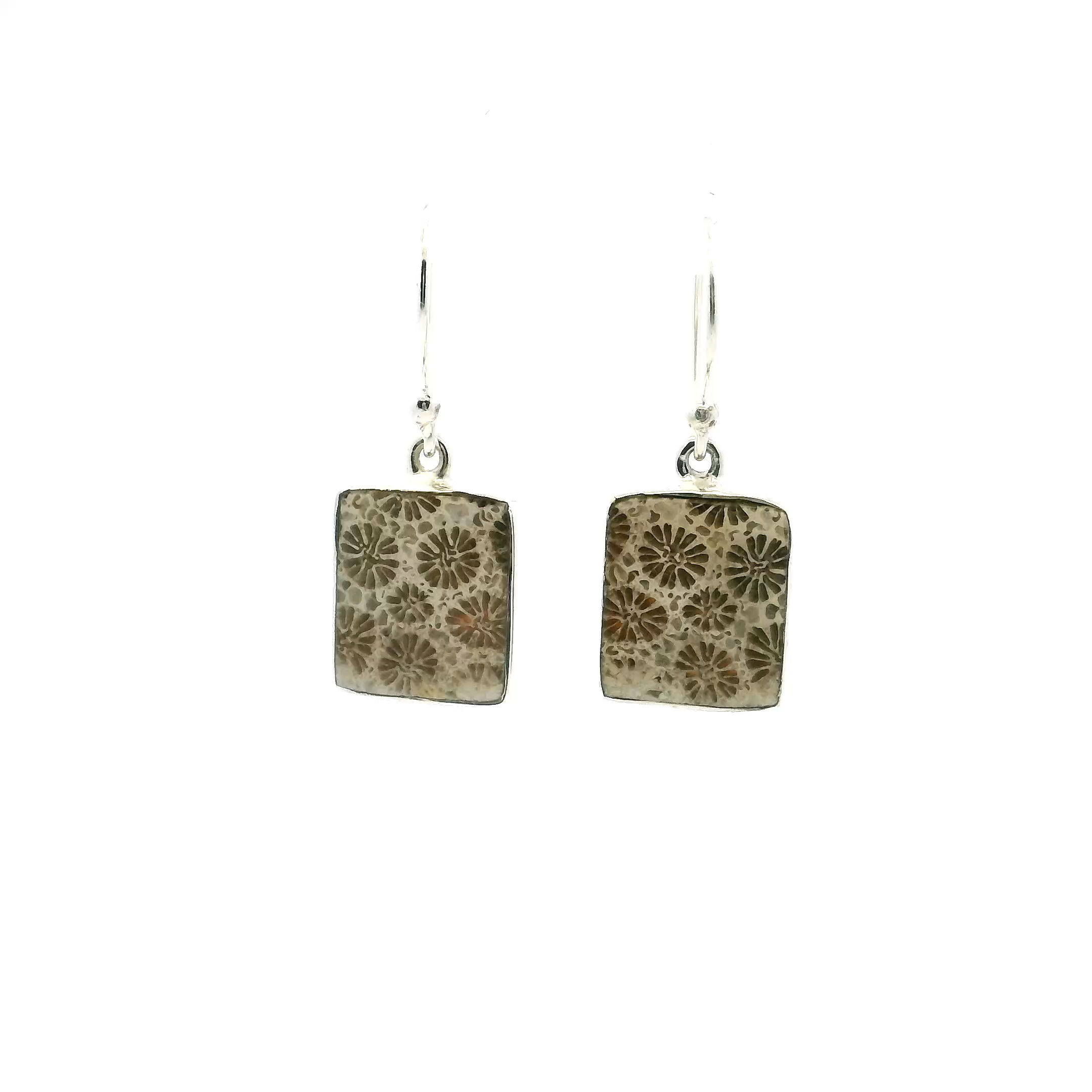 These Fossilized Coral Dangle Earrings feature square cabochons with intricate dark floral patterns naturally embedded in a light-toned matrix, each piece offering a unique glimpse into prehistoric marine life. Bezel set in high-quality 925 sterling silver, the clean lines and gentle dangle create a refined silhouette that effortlessly transitions from casual wear to formal attire.Crafted for those who appreciate the quiet elegance of natural materials, these earrings combine organic texture with minimalist design, allowing the fossilized coral’s delicate structure to take center stage. Lightweight yet impactful, they bring timeless character and thoughtful craftsmanship to any jewelry collection. Fossilized Coral Dangle Earrings - Square Cabochon with Dark Flowers in Light Background Bezel Set in 925 Sterling Silver
