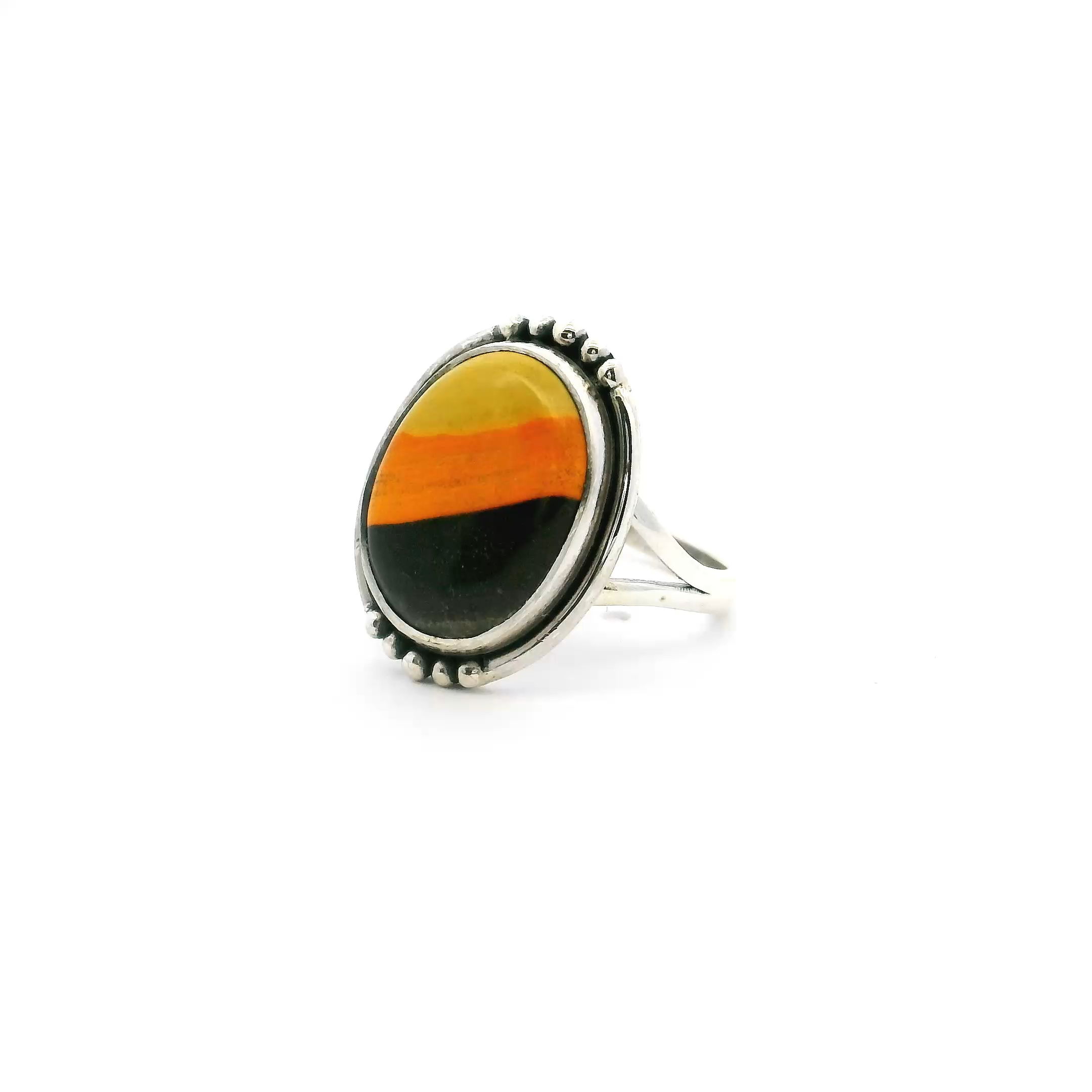 This eye-catching ring features an oval Bumblebee Jasper cabochon with vivid swirls of yellow, orange, and grey—bezel set in polished 925 sterling silver. A double band and beaded accents add modern elegance to this bold, tri-color stone.Sized for a perfect fit at size 5, it’s ideal for everyday wear or special occasions. A vibrant, one-of-a-kind piece that brings natural energy and standout style to any jewelry collection. Bumblebee Jasper Ring - Oval Tri-color Cabochon with Double Band & Beaded Accents Bezel Set in 925 Sterling Silver sz5