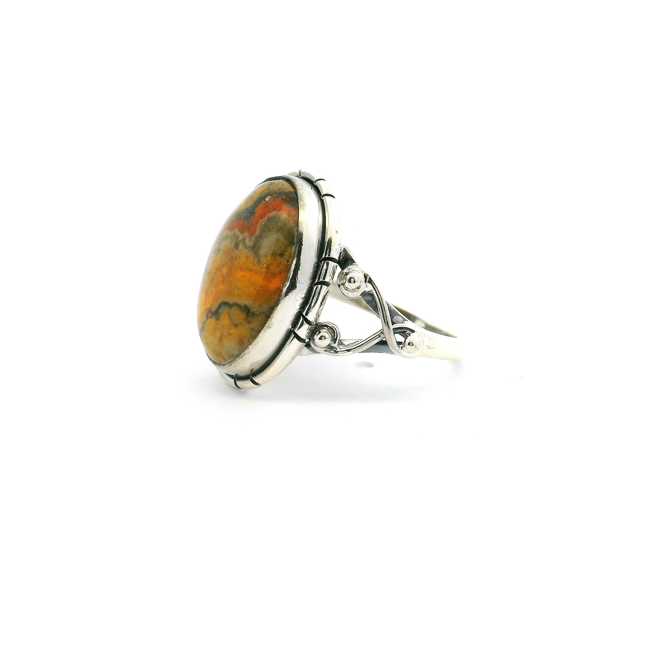 This eye-catching ring features an oval Bumblebee Jasper cabochon with vivid swirls of yellow, orange, and grey—bezel set in polished 925 sterling silver. A double band and beaded accents add modern elegance to this bold, tri-color stone.A vibrant, one-of-a-kind piece that brings natural energy and standout style to any jewelry collection. Bumblebee Jasper Ring - Oval Tri-color Cabochon with Double Band & Side Wishbone Accents Bezel Set in 925 Sterling Silver sz6