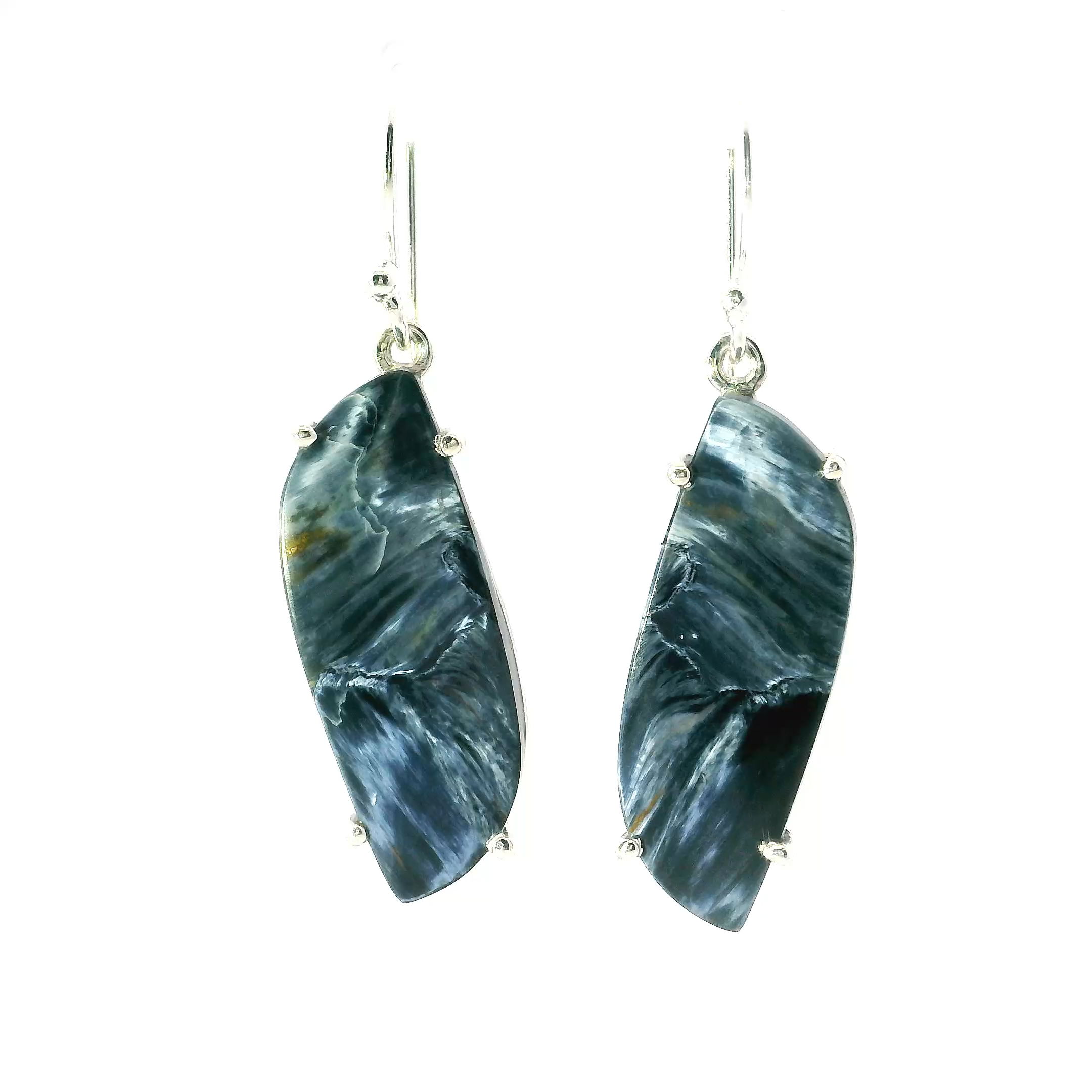 These elegant dangle earrings feature S-shaped Pietersite cabochons, prong set in polished 925 sterling silver. Known for their swirling patterns of deep blue, gold, and brown, each stone is naturally unique and full of depth.Lightweight and eye-catching, they offer graceful movement and timeless style—perfect for everyday wear or special occasions. A striking addition to any jewelry collection, celebrating nature’s artistry in refined form. Pietersite Dangle Earrings - S-Shaped Cabochon Prong Set in 925 Sterling Silver