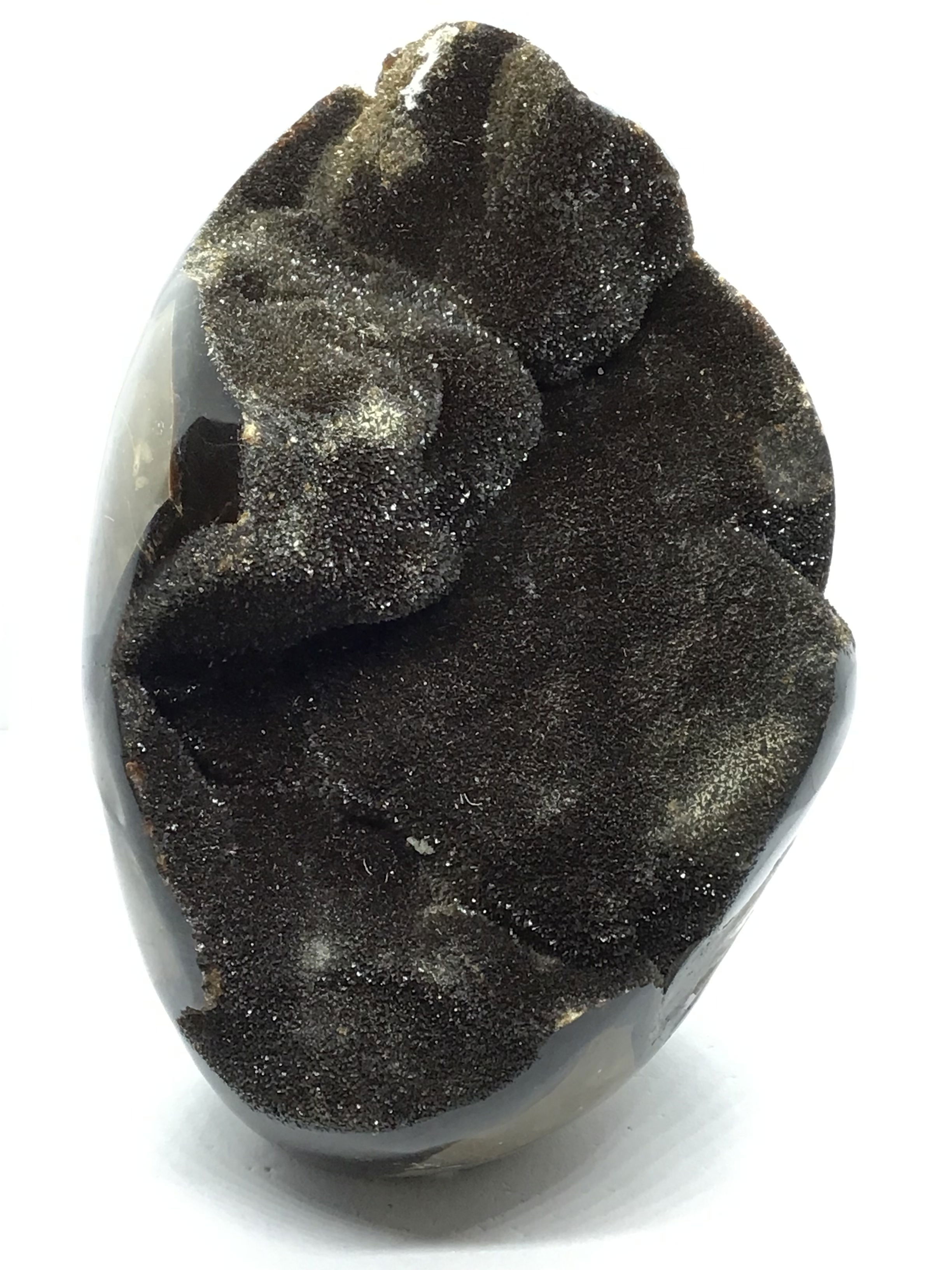 Hand-selected from Madagascar, this Septarian Geode Egg showcases a captivating blend of yellow calcite, brown aragonite, and gray limestone. Sparkling druze crystals light up its center, while bold natural patterns and a smooth cut base offer balance and elegance.Perfect as a gift or decor accent, it’s a one-of-a-kind piece that celebrates Earth’s ancient beauty and artistry—ideal for collectors, nature lovers, or anyone drawn to unique natural treasures. Septarian Druze Geode Freeform Egg with Cut Base from Madagascar