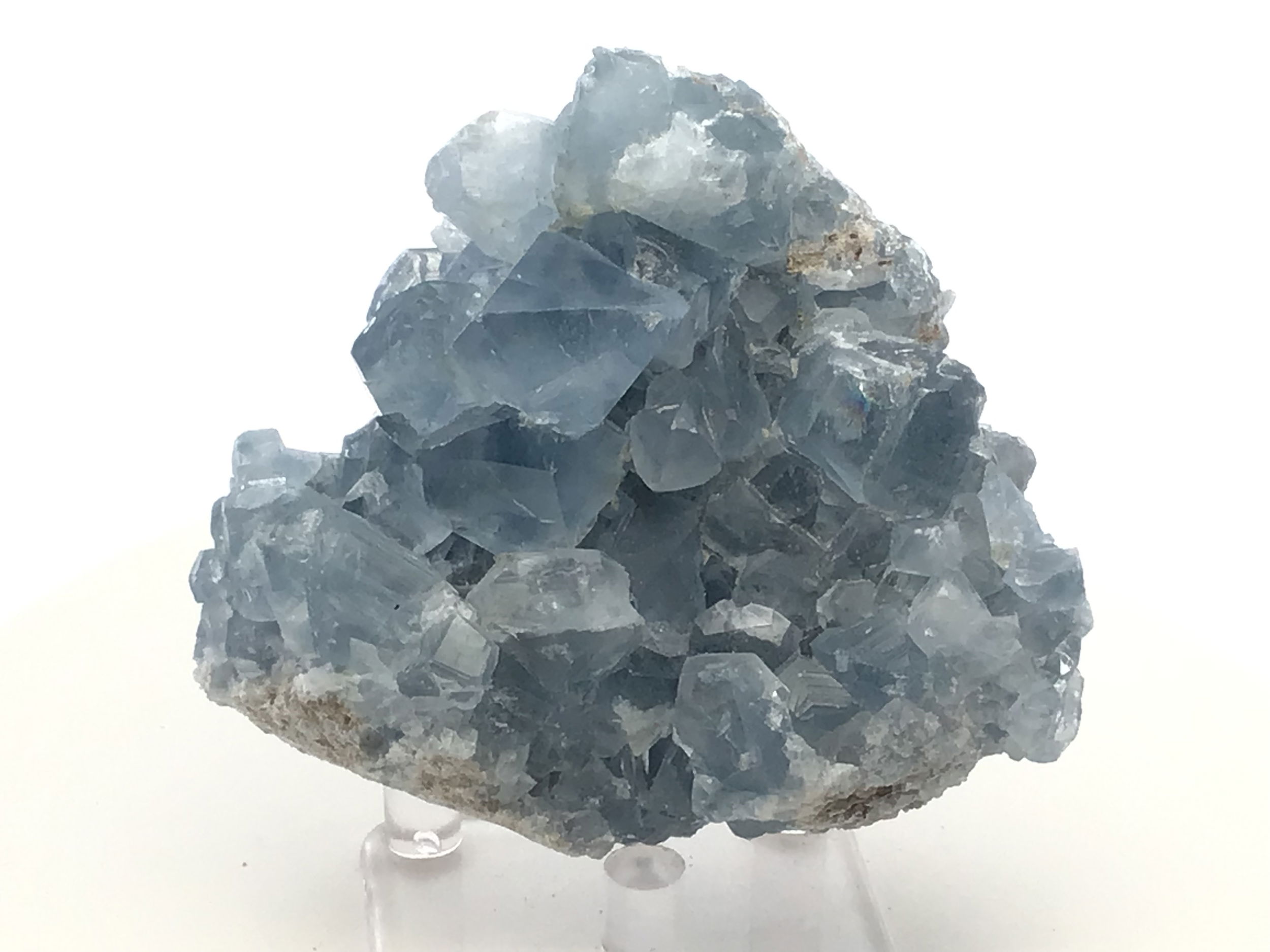 Known for its serene blue hues and delicate crystal formations, this remarkable specimen captures the essence of celestial wonder, offering a tranquil energy to any space it graces.Expertly sourced from the rich mineral deposits of Madagascar, each Celestine specimen is naturally unique, displaying its own distinct crystal structure and shades of blue, reminiscent of a clear sky infused with peace and harmony.Accompanied by a clear, sleek Lucite stand, this Celestine specimen is elegantly showcased, elevating its aesthetic appeal. The stand not only enhances the crystal's natural beauty but also provides stability and a modern touch to complement any decor.Celestine is renowned for its calming and uplifting properties, often used to promote clarity of mind and enhance communication. This crystal can be a powerful ally for meditation, encouraging a sense of tranquility and spiritual awareness. Celestine Crystal Specimen from Madagascar with Lucite Stand
