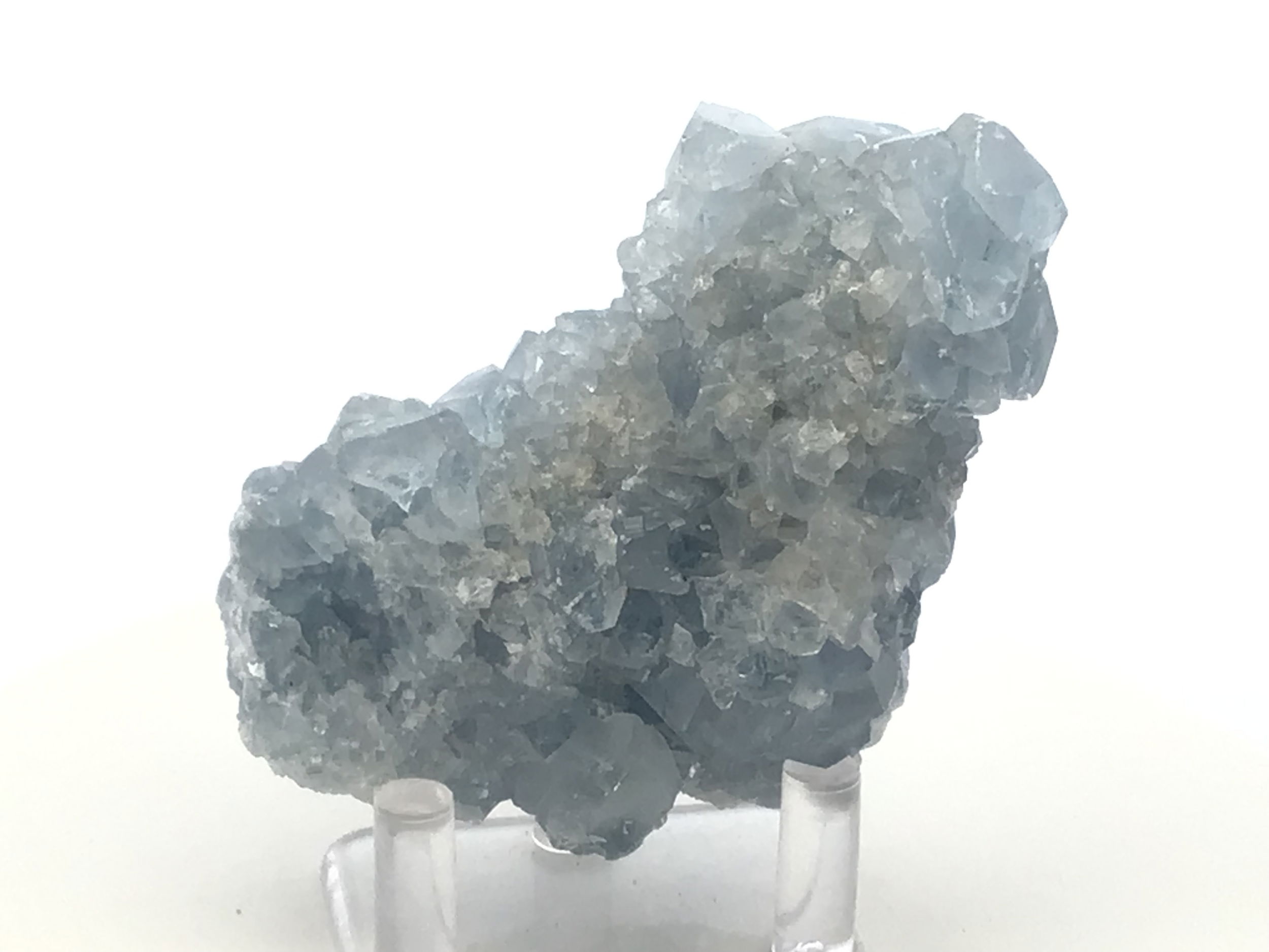 Known for its serene blue hues and delicate crystal formations, this remarkable specimen captures the essence of celestial wonder, offering a tranquil energy to any space it graces.Expertly sourced from the rich mineral deposits of Madagascar, each Celestine specimen is naturally unique, displaying its own distinct crystal structure and shades of blue, reminiscent of a clear sky infused with peace and harmony. Accompanied by a clear, sleek Lucite stand, this Celestine specimen is elegantly showcased, elevating its aesthetic appeal. The stand not only enhances the crystal's natural beauty but also provides stability and a modern touch to complement any decor.Celestine is renowned for its calming and uplifting properties, often used to promote clarity of mind and enhance communication. This crystal can be a powerful ally for meditation, encouraging a sense of tranquility and spiritual awareness. Celestine Crystal Specimen from Madagascar with Lucite Stand