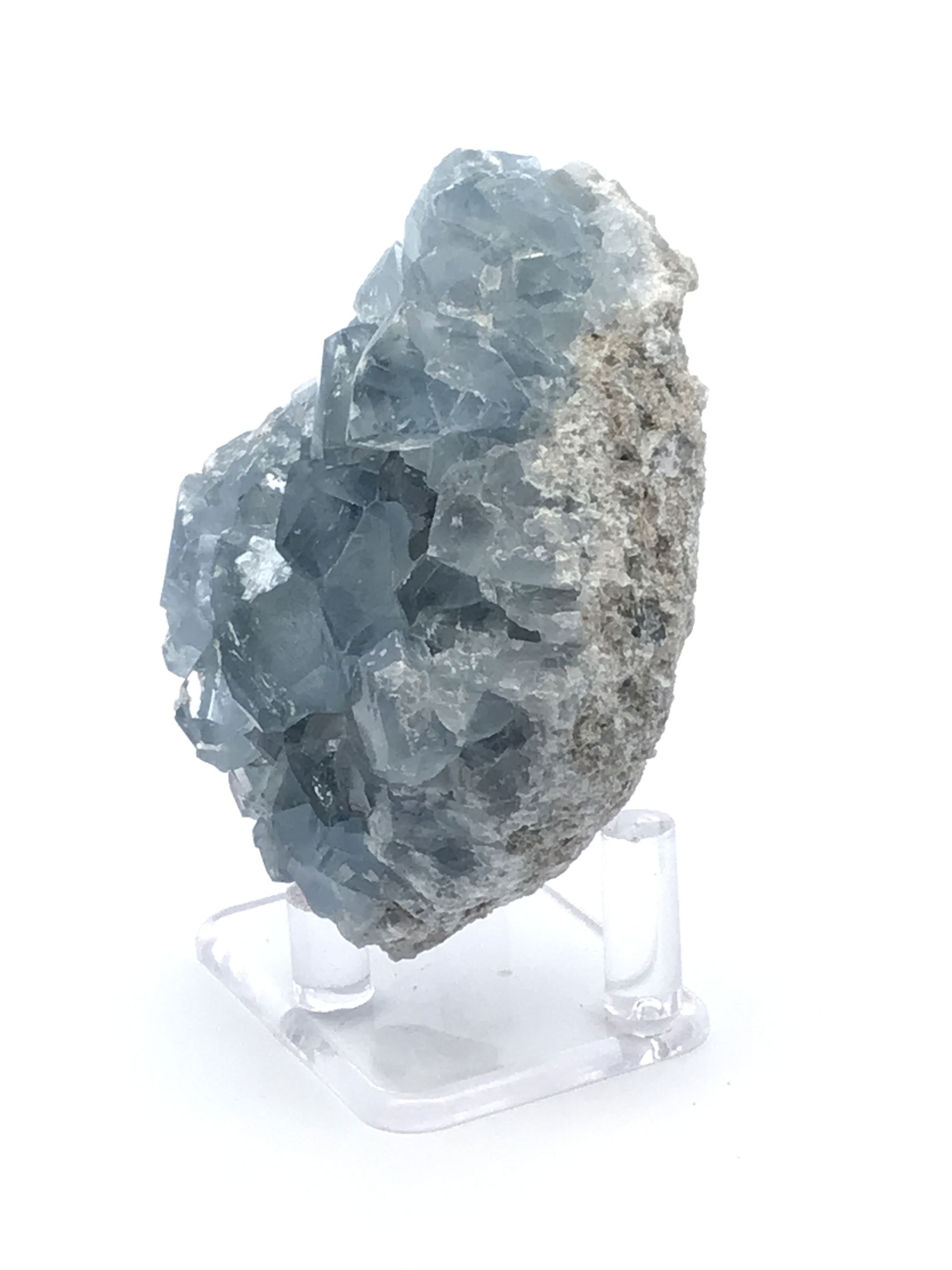 This exquisite celestine specimen from Madagascar features delicate, sky-blue crystals that shimmer with tranquil beauty. Nestled on a sleek lucite stand, it’s elegantly elevated for full appreciation from every angle.Ideal for collectors, decorators, or those drawn to calming energy, this piece brings a peaceful presence and natural grace to any space—a timeless showcase of Earth’s quiet brilliance. Celestine Crystal Specimen from Madagascar with Lucite Stand