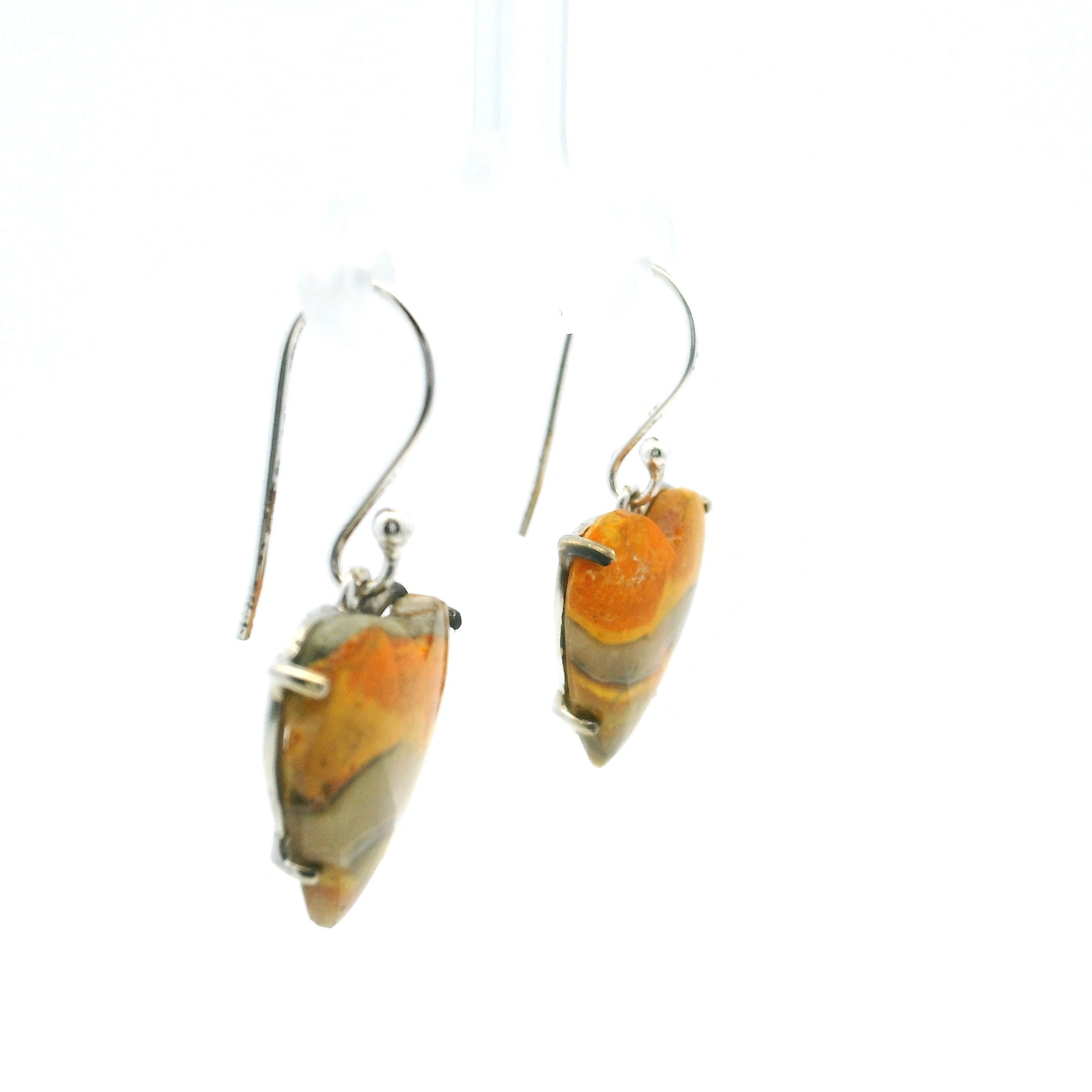 Experience the vibrant elegance of our Bumblebee Jasper Dangle Earrings, featuring heart-shaped cabochons prong-set in lustrous 925 sterling silver. Each stone showcases vivid horizontal banding in bold shades of orange, yellow, and gray—an energetic palette that evokes the movement of lava and sunlight across stone. The silver setting frames the jasper’s natural brilliance while providing a lightweight, secure fit perfect for all-day wear.Artful and expressive, these earrings add a joyful sophistication to any outfit, effortlessly transitioning from casual daytime looks to evening ensembles. With their playful heart shape and striking color variation, no two pairs are alike, making them as unique as the woman who wears them. A celebration of bold beauty and confident individuality, the Bumblebee Jasper Dangle Earrings are a radiant choice for collectors and style lovers alike. Bumblebee Jasper Dangle Earrings - Heart Cabochon with Horizontal Orange & Yellow & Gray Banding Prong Set in 925 Sterling Silver