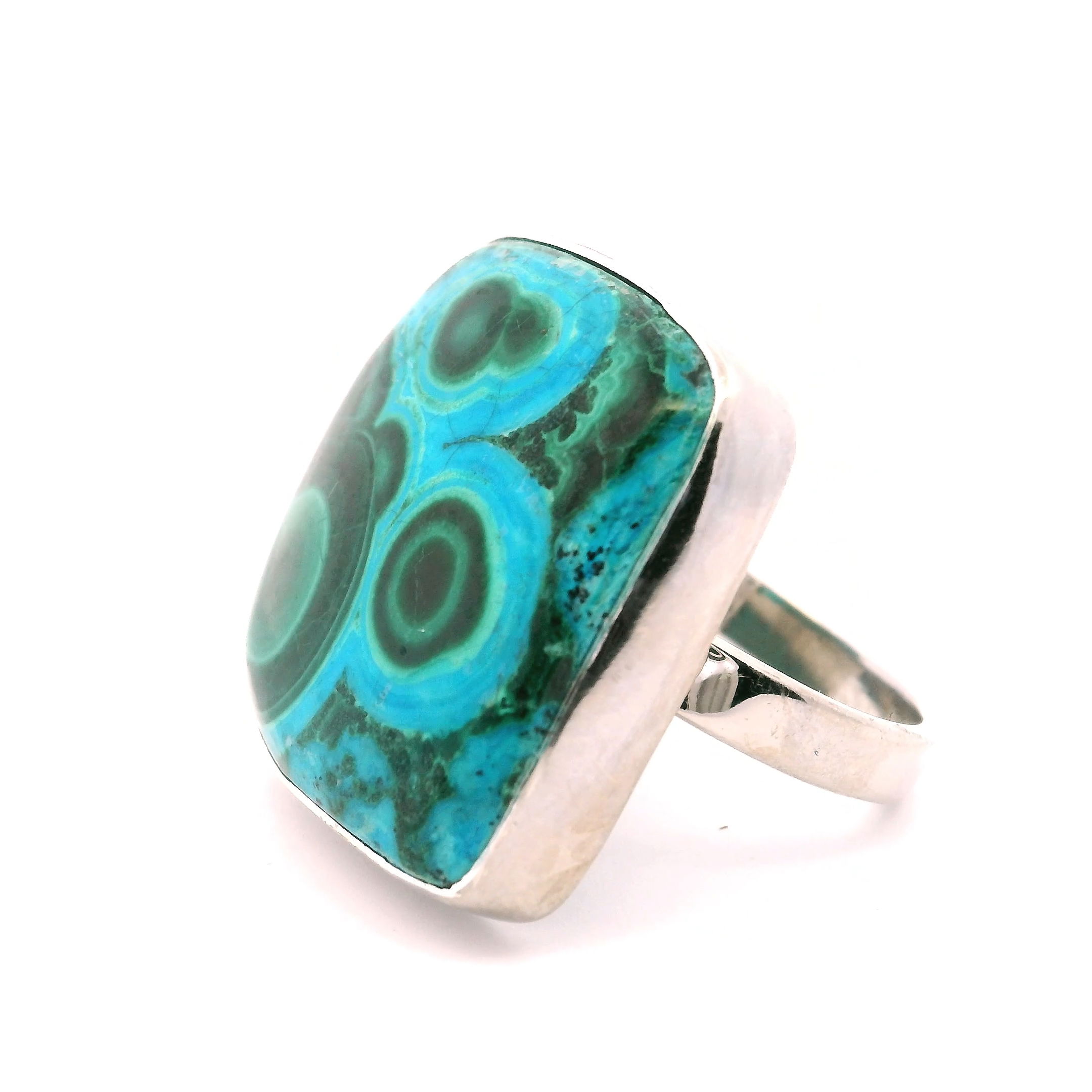 Showcasing vivid deep greens and striking triple bullseye patterns, this Chrysocolla Malachite Ring features a square cabochon bezel set in simple 925 sterling silver. The natural fusion of chrysocolla and malachite creates a one-of-a-kind gemstone with rich, swirling textures that make every ring unique.Elegant yet bold, this ring is perfect for daily wear or special occasions—a stunning tribute to nature’s artistry and refined design. Chrysocolla Malachite Ring - Square Cabochon With Green Triple BullsEyes Bezel Set In Simple 925 Sterling Silver szAdj