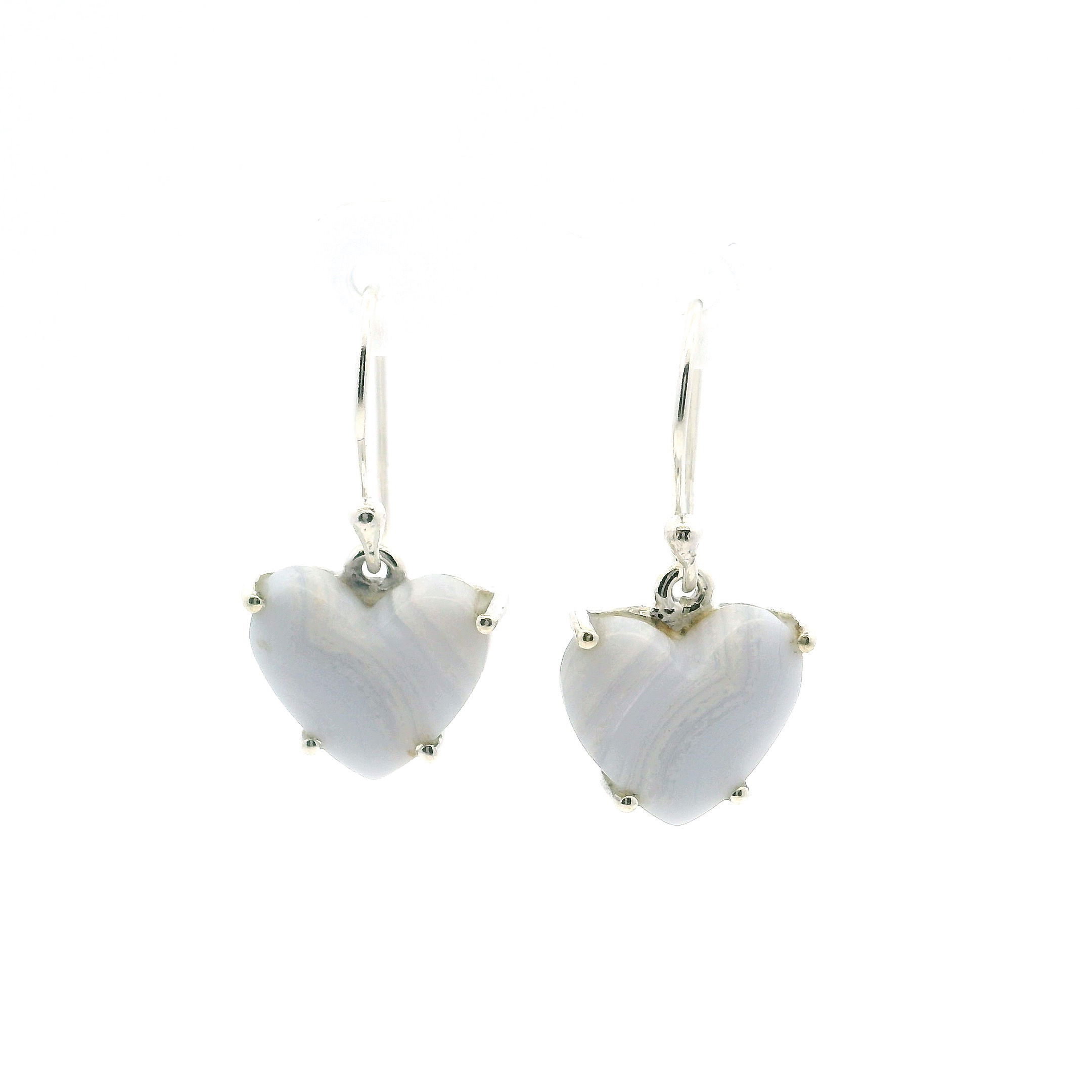 Blue Lace Agate Dangle Earrings embody the quiet elegance of nature’s artistry. Featuring heart-shaped cabochons with delicate angled bands in soft blue and white, each stone is prong-set in polished 925 sterling silver to highlight its tranquil beauty.Graceful and refined, these earrings sway gently with every movement, offering a serene statement suited for both everyday wear and special occasions. A timeless expression of calm and clarity, they’re a meaningful addition to any jewelry collection. Blue Lace Agate Dangle Earrings - Heart Cabochon with Narrow Angled Banding Prong Set in 925 Sterling Silver