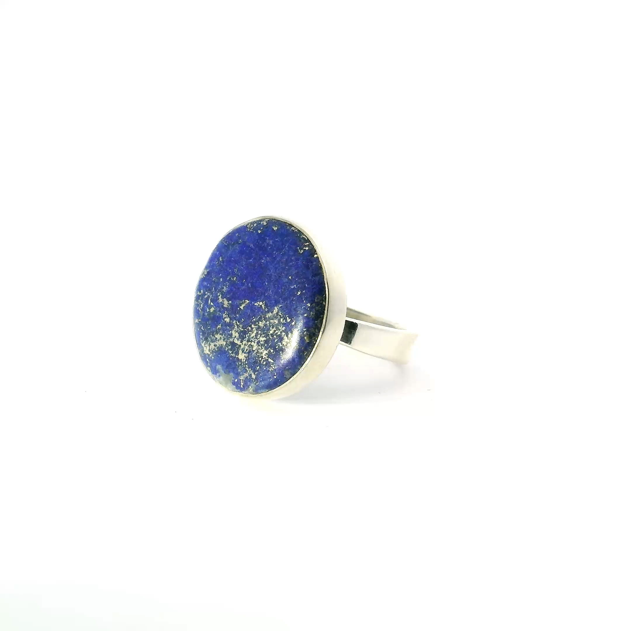 This Lapis Lazuli Ring with Round Cabochon Bezel Set in Simple 925 Sterling Silver (Size 5) features a rich ultramarine gemstone, polished into a smooth, classic dome and flecked with natural golden pyrite that evokes a star-strewn night sky. The stone is securely bezel set in minimalist sterling silver, offering a timeless, refined silhouette that allows the vivid lapis to take center stage.Sized at US 5, this ring is ideal for everyday wear or as a subtle accent for special occasions. Its clean, understated design highlights the inherent beauty of lapis lazuli—long treasured as a symbol of wisdom, truth, and inner strength—making it a meaningful and elegant addition to any jewelry collection. Lapis Lazuli Ring - Round Cabochon Bezel Set in Simple 925 Sterling Silver sz5