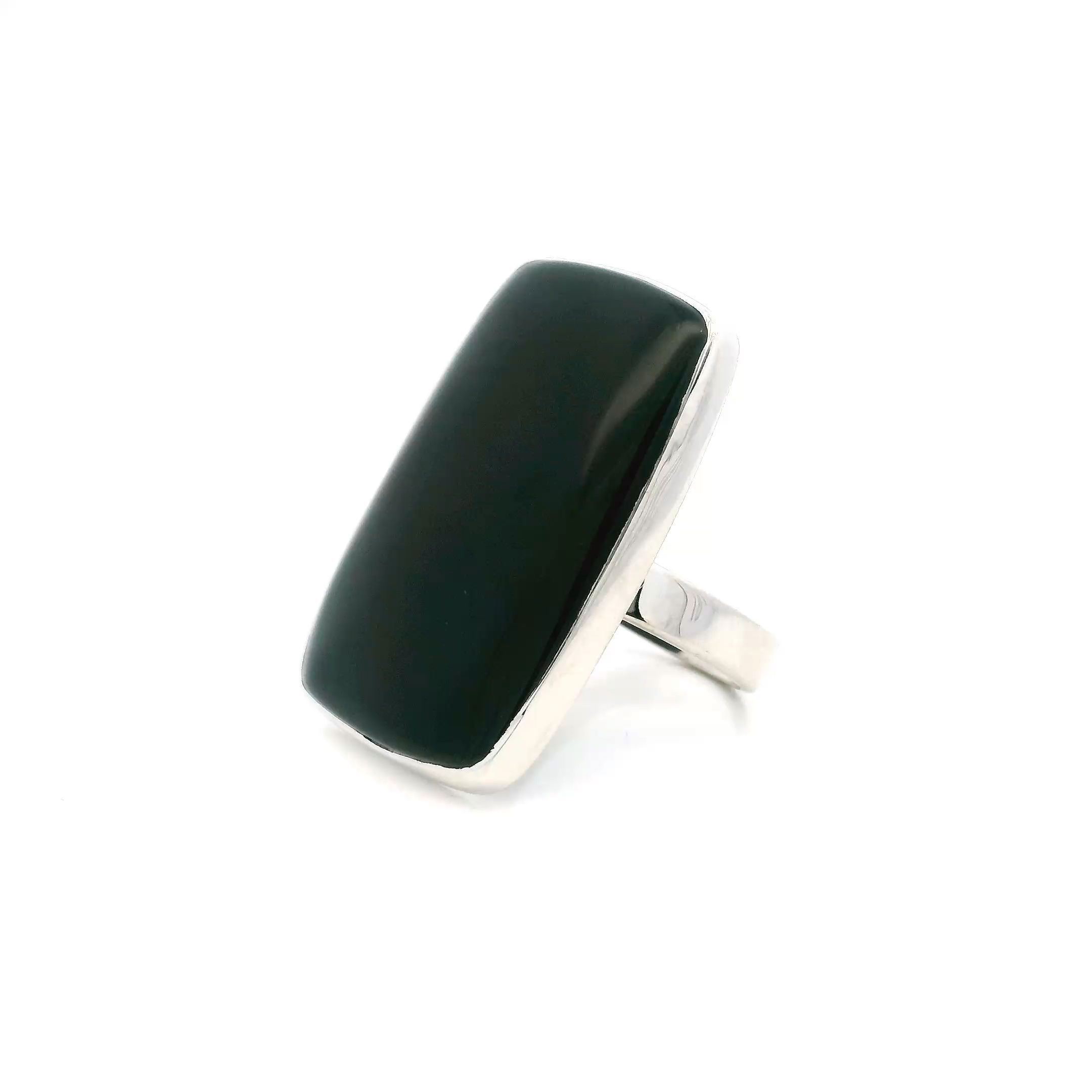 This Black Onyx Ring with Rounded Rectangle Cabochon in Adjustable 925 Sterling Silver is a refined expression of minimalist elegance, featuring a smooth cabochon of deep black onyx, bezel set in sleek, polished silver. The stone’s velvety luster evokes quiet strength and mystery, its inky surface catching light with subtle flashes of depth and contrast.Designed with a slender, open band that adjusts easily to fit a range of sizes, this piece balances comfort with contemporary style. The sterling silver setting provides a clean, luminous frame, allowing the rich tone of the onyx to take center stage. A versatile staple for any wardrobe, this ring adds a modern edge to everyday looks and a touch of quiet glamour to evening attire—an ideal choice for women drawn to timeless design with a hint of intrigue. Black Onyx Ring - Rounded Rectangle Cabochon Bezel Set in Simple 925 Sterling Silver szAdj