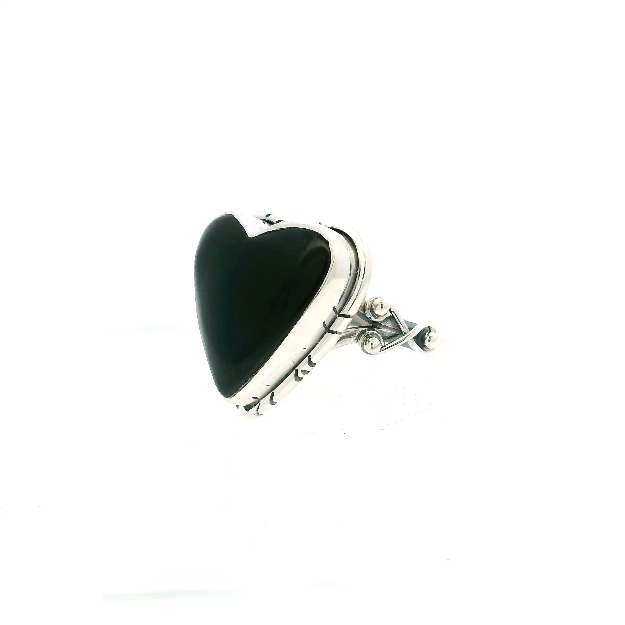 This Black Onyx Ring with Heart Cabochon in 925 Sterling Silver, Size 10, features a richly polished heart-shaped onyx set in a smooth bezel, its glossy surface radiating quiet strength and refined allure. The gemstone’s deep black hue is framed by intricate silverwork—fine lines and delicate bead accents along a wishbone-inspired double band—offering both textural contrast and sculptural elegance.Crafted in high-quality sterling silver, this ring balances bold sentiment with a sleek silhouette, making it a striking choice for those drawn to both classic design and distinctive details. Whether worn as a symbol of love or a statement of personal style, it’s a meaningful addition to any collection—perfect for everyday sophistication or standout occasions alike. Black Onyx Ring - Heart Cabochon with Line Details Bezel Set in Double Band with Wishbone & Bead Sides in 925 Sterling Silver sz10