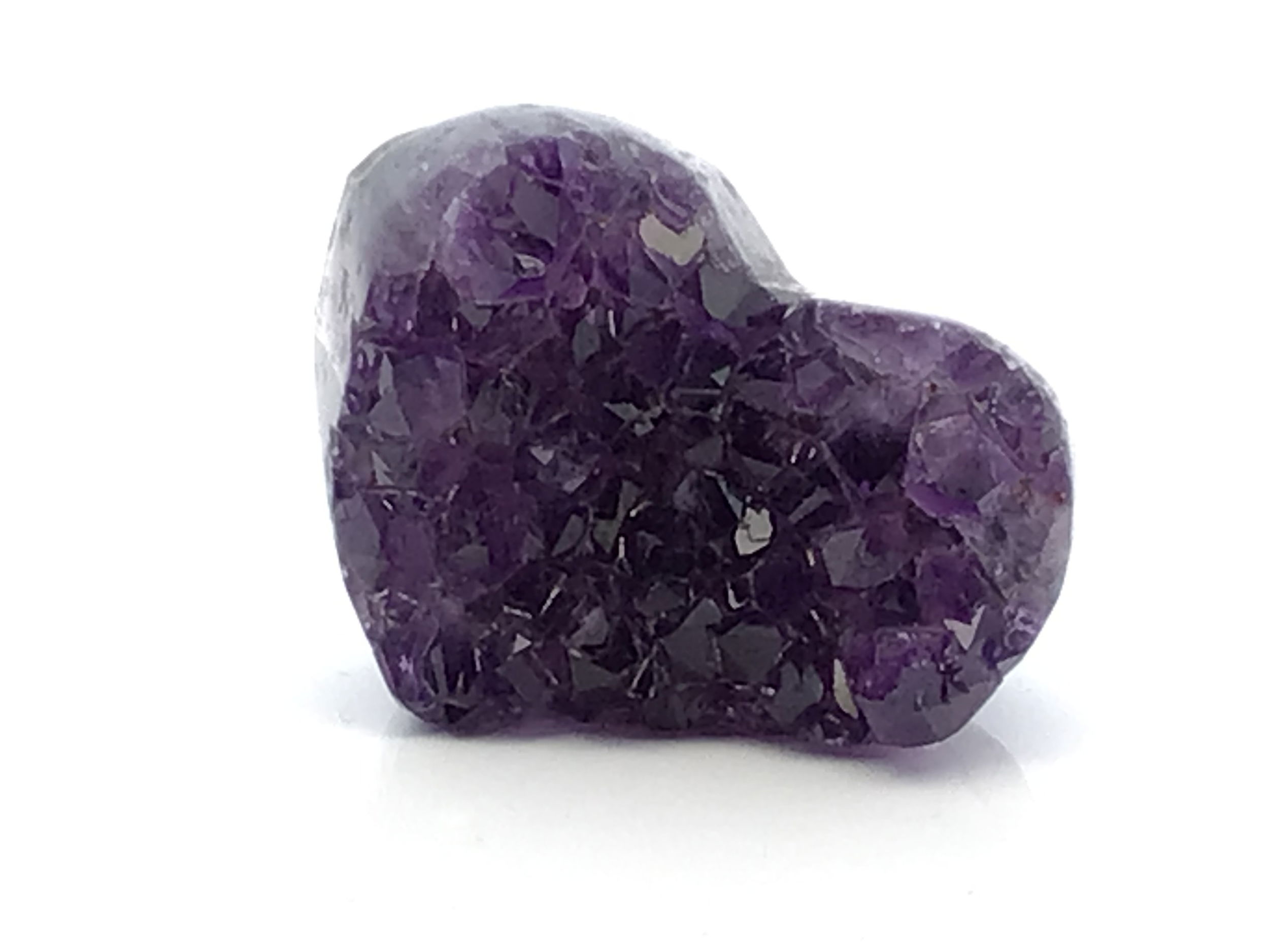 The Amethyst Crystal Heart on Lucite Cluster Stand is a luminous fusion of sculpted gemstone and minimalist design, perfect for gifting or enhancing your sacred space. This hand-carved amethyst heart glows in soothing shades of violet and lilac, its natural crystalline facets radiating tranquility, clarity, and emotional balance. Symbolizing compassion and inner peace, the heart rests atop a clear lucite cluster stand that elevates and frames the stone with subtle, modern elegance.A poetic interplay of organic form and contemporary geometry, this piece offers both aesthetic impact and metaphysical resonance. Whether displayed as a centerpiece or nestled into a crystal collection, it invites serenity and spiritual growth into any room. A timeless treasure for the crystal lover, the design-forward minimalist, or anyone drawn to the gentle power of amethyst. Amethyst Crystal Heart on Lucite Cluster Stand