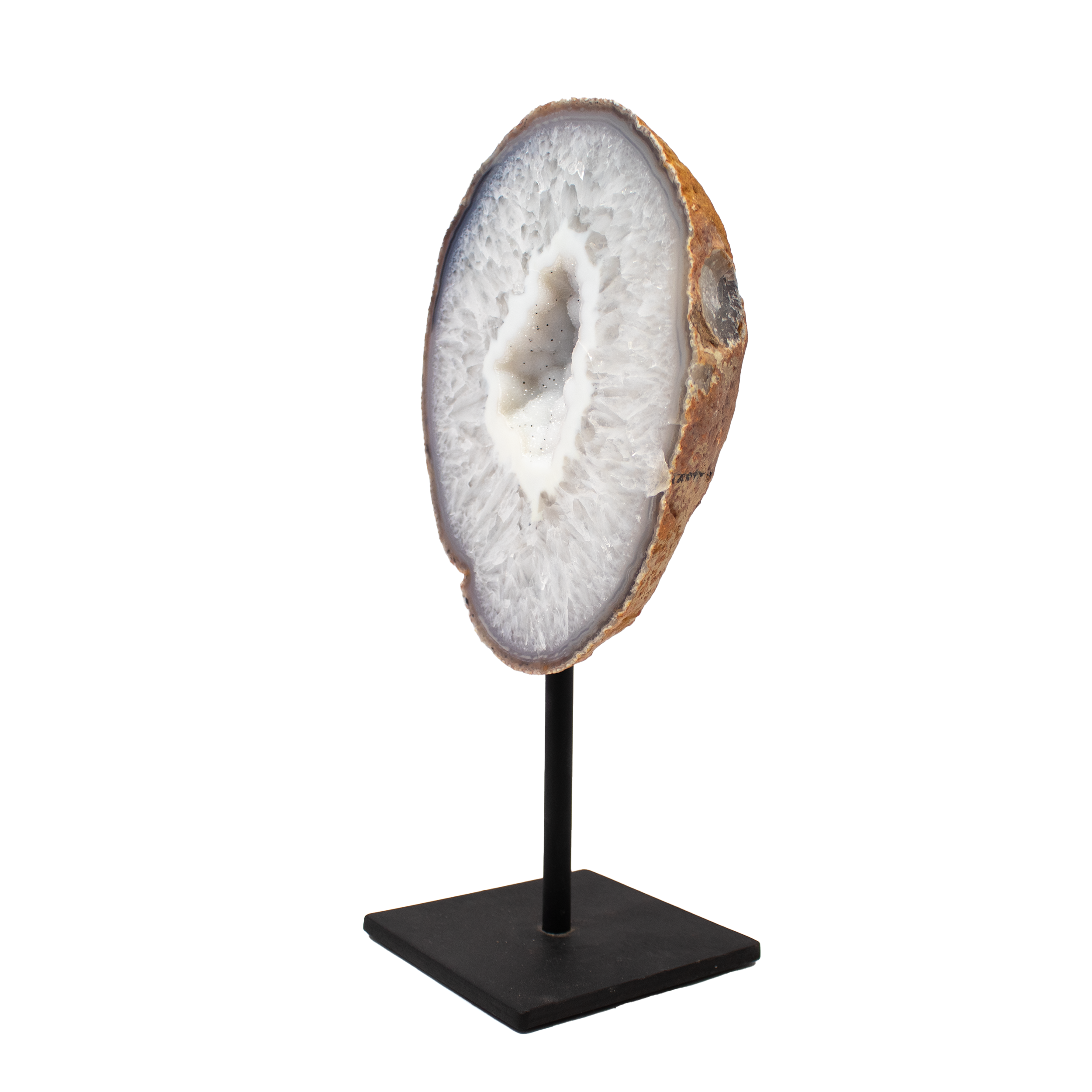 The Agate Druze Geode on Post Stand from Brazil features a breathtaking formation of shimmering quartz crystals framed by a striking white agate band, offering a perfect balance of raw natural beauty and refined design. Mounted securely on a sleek metal stand, the piece stands upright as a dramatic tabletop accent, allowing its intricate patterns and radiant sparkle to be admired from every angle.Hand-selected for its unique composition and luminous presence, this geode brings a touch of elegance and grounding energy to any room. Agate is cherished for its stabilizing properties, making this specimen not only a stunning visual statement but also a subtle anchor of peace and clarity. Ideal for collectors, interior enthusiasts, or anyone seeking to infuse their space with the quiet majesty of the mineral world. Agate Druze Geode on Post Stand from Brazil with Classic Quartz and White Agate Band Center