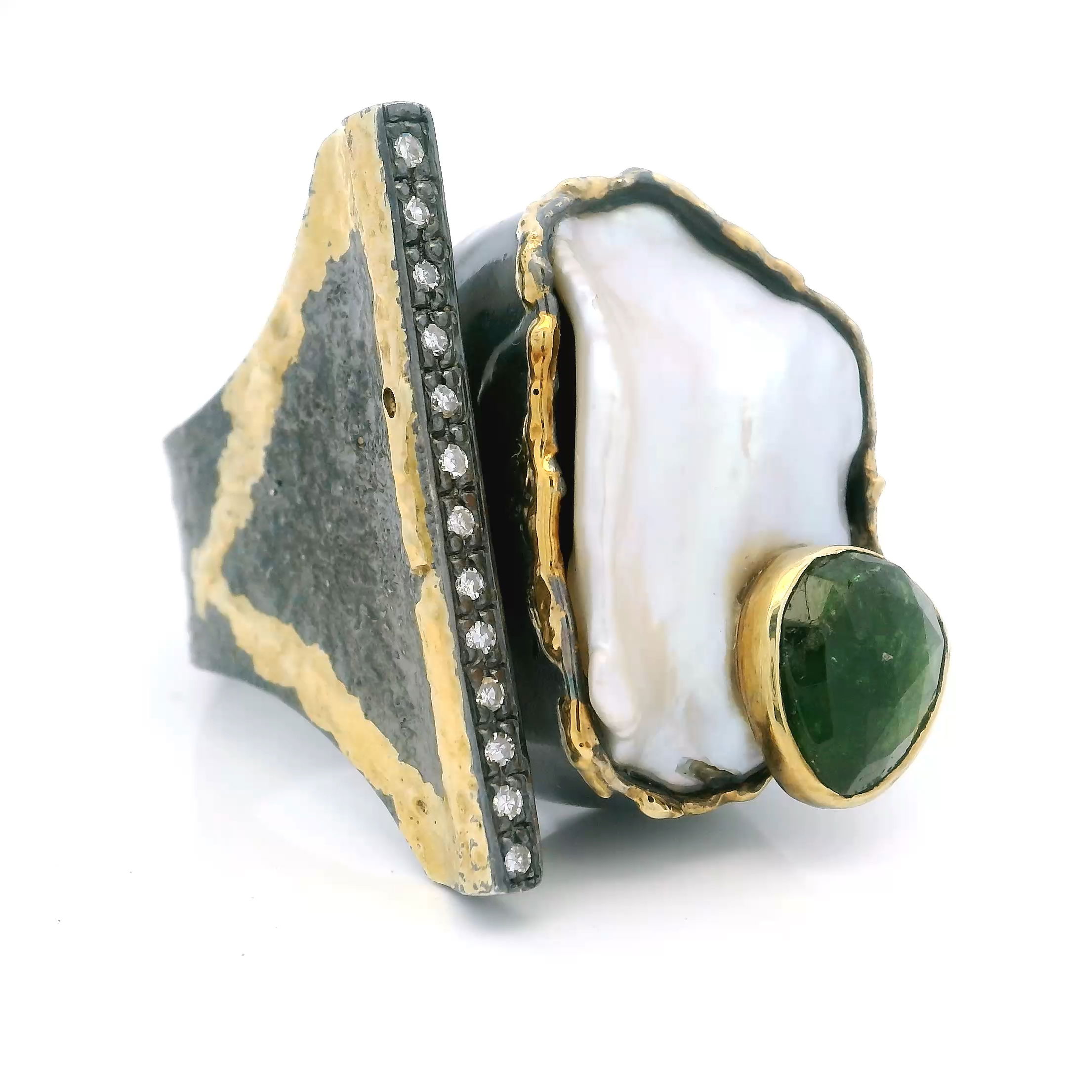 Elevate your jewelry collection with this exquisite Keshi Pearl Ring in 925 Sterling Silver, designed as a bold statement piece. A naturally unique, lustrous Keshi pearl forms the centerpiece, paired harmoniously with a faceted green tourmaline that adds a lively splash of color.The open band design sparkles with a single row of pavé-set diamonds, lending subtle brilliance, while a dripped gold triangular bezel accent introduces a modern geometric flair. Crafted in size 9.5, this ring perfectly balances organic elegance with contemporary artistry for the woman who values sophisticated, distinctive jewelry. Keshi Pearl Ring - Keshi pearl & Faceted Green Tourmaline on Open Band with Single Row Pave Diamonds & Dripped Gold Triangular Accent Bezel Set in 925 Sterling Silver sz9.5
