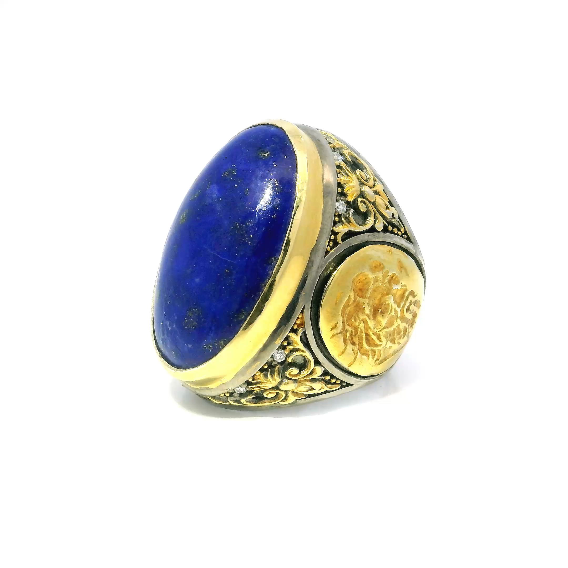 Discover timeless elegance with this stunning Lapis Lazuli Ring, featuring an oval cabochon centerpiece framed by eight sparkling diamonds. Intricately crafted in 925 sterling silver, the ring’s bezel is accented by a gold side coin bearing the image of a bearded man—an artistic nod to classical antiquity. Delicate floral details complete the design, adding softness and charm to the bold silhouette.Sized at 9, this exceptional ring is perfect for those who value refined craftsmanship and meaningful design. A striking blend of classic beauty and distinctive flair, it’s a standout addition to any jewelry collection. Lapis Lazuli Ring - Oval Cabochon & 8 Diamonds with Gold Side Bearded Man Coin & Floral Details Bezel Set in 925 Sterling Silver sz9