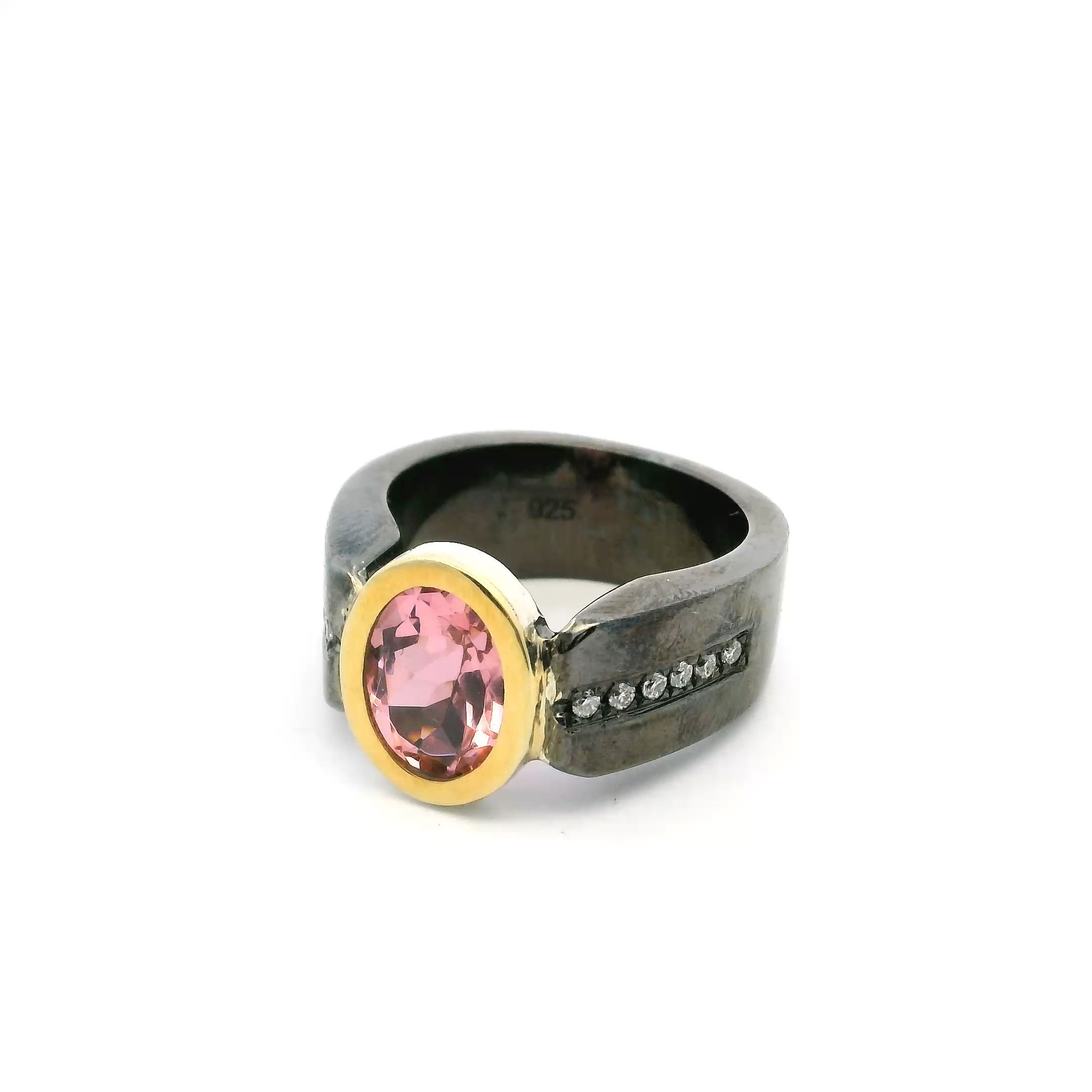 Elevate your look with this stunning Cubic Zirconia Ring, masterfully crafted in oxidized sterling silver for a bold, contemporary edge. The brilliant faceted oval cubic zirconia centerpiece is bezel set and accented with radiant gold, adding a touch of luxury.Flush-set sparkling diamonds cascade down both sides of the band, enhancing the ring’s elegance and eye-catching appeal. Designed in size 8.5, this ring perfectly blends timeless sophistication with modern artistry—an irresistible addition to any jewelry collection. Cubic Zirconia Ring - Faceted Oval with Diamonds Down Both Sides of Band Bezel Set Flush in Oxidized Sterling Silver with Gold Accent sz8.5