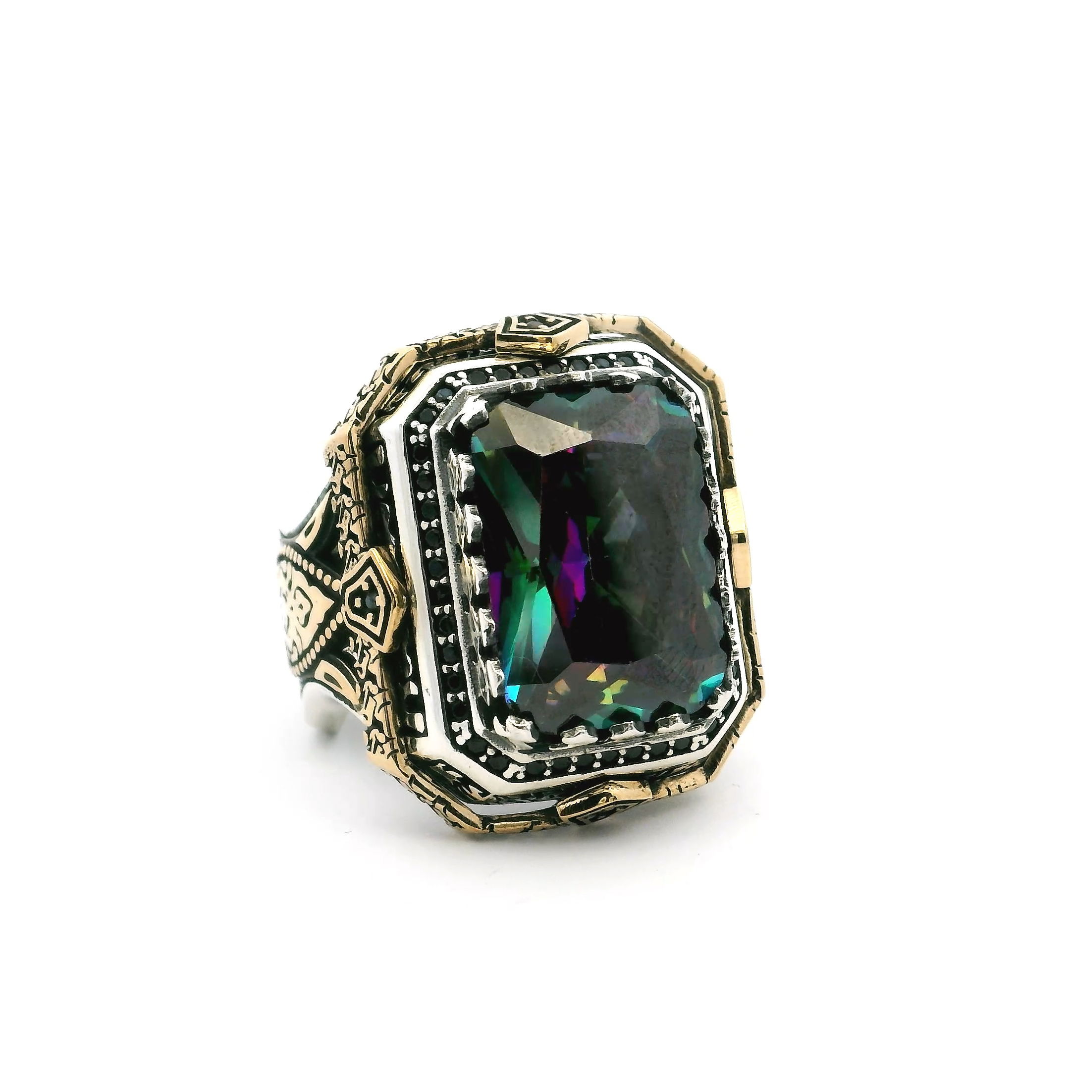 Elevate your style with this bold Mystic Topaz Ring, expertly crafted in solid 925 sterling silver and finished with a luxurious layer of gold vermeil. The centerpiece features a mesmerizing faceted rectangle-cut mystic topaz, capturing iridescent flashes of color with every movement. Its distinctive sawtooth setting adds texture and intrigue, while a single row of pavé-set black nanostones along the band brings a modern, masculine edge.Sized at 8.5, this striking ring makes a confident statement for any occasion—perfect for those who appreciate unique style and quality craftsmanship in their jewelry collection. Mystic Topaz Ring - Faceted Rectangle in Designer Sawtooth Setting with Single Row Pave Black Nanostones in 925 Sterling Silver with Gold Vermeil sz8.5