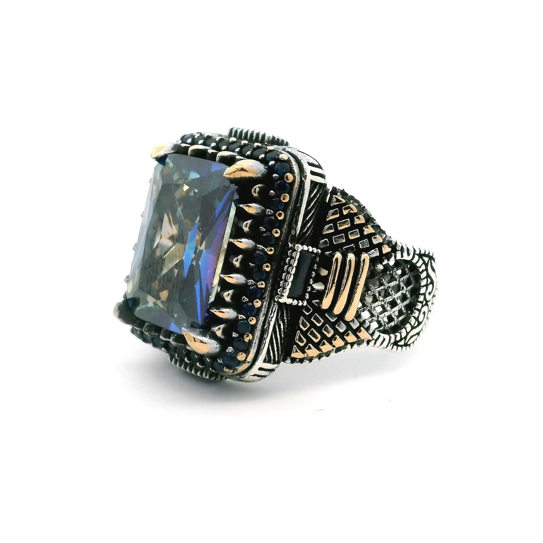 Discover a bold statement with this Blue Mystic Topaz Ring, crafted for the modern man. A faceted rectangular blue mystic topaz radiates vibrant hues with every movement, secured in a distinctive sawtooth setting that adds sophisticated edge.Sapphire nanostones sparkle along each side, while four sleek sterling silver rectangles frame the centerpiece, accented by rich gold vermeil for a touch of opulence. Made from genuine 925 sterling silver and sized at 11, this ring embodies refined style—an extraordinary addition to any men's jewelry collection. Blue Mystic Topaz Ring - Faceted Rectangle in Designer Sawtooth Setting with Sapphire Nanostones & 4 Rectangles in 925 Sterling Silver with Gold Vermeil Accents sz11