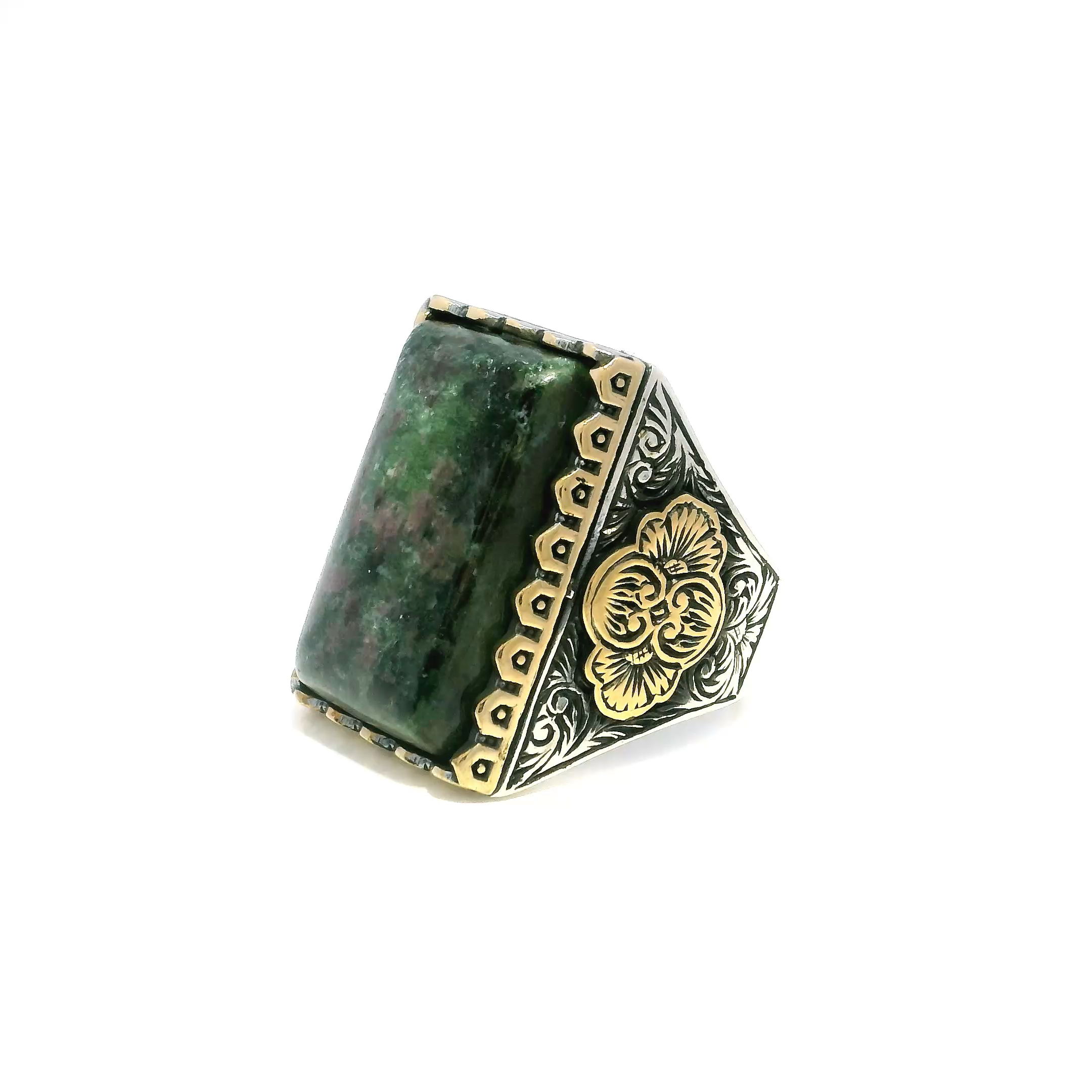 Elevate your style with this striking Ruby Zoisite Ring, featuring a rectangular pillow cabochon that showcases the mesmerizing blend of deep ruby and vibrant green zoisite. The stone is set in a meticulously crafted designer sawtooth bezel, creating a bold focal point.The 925 sterling silver band is accented with luxurious gold vermeil touches, adding sophisticated contrast and a touch of glamour. Designed in size 12 for a comfortable fit, this unique ring perfectly balances artisan craftsmanship with timeless elegance—making it a standout piece for any jewelry collection. Ruby Zoisite Ring - Rectangular Pillow Cabochon in Designer Sawtooth Setting in 925 Sterling Silver with Gold Vermeil Accents sz12