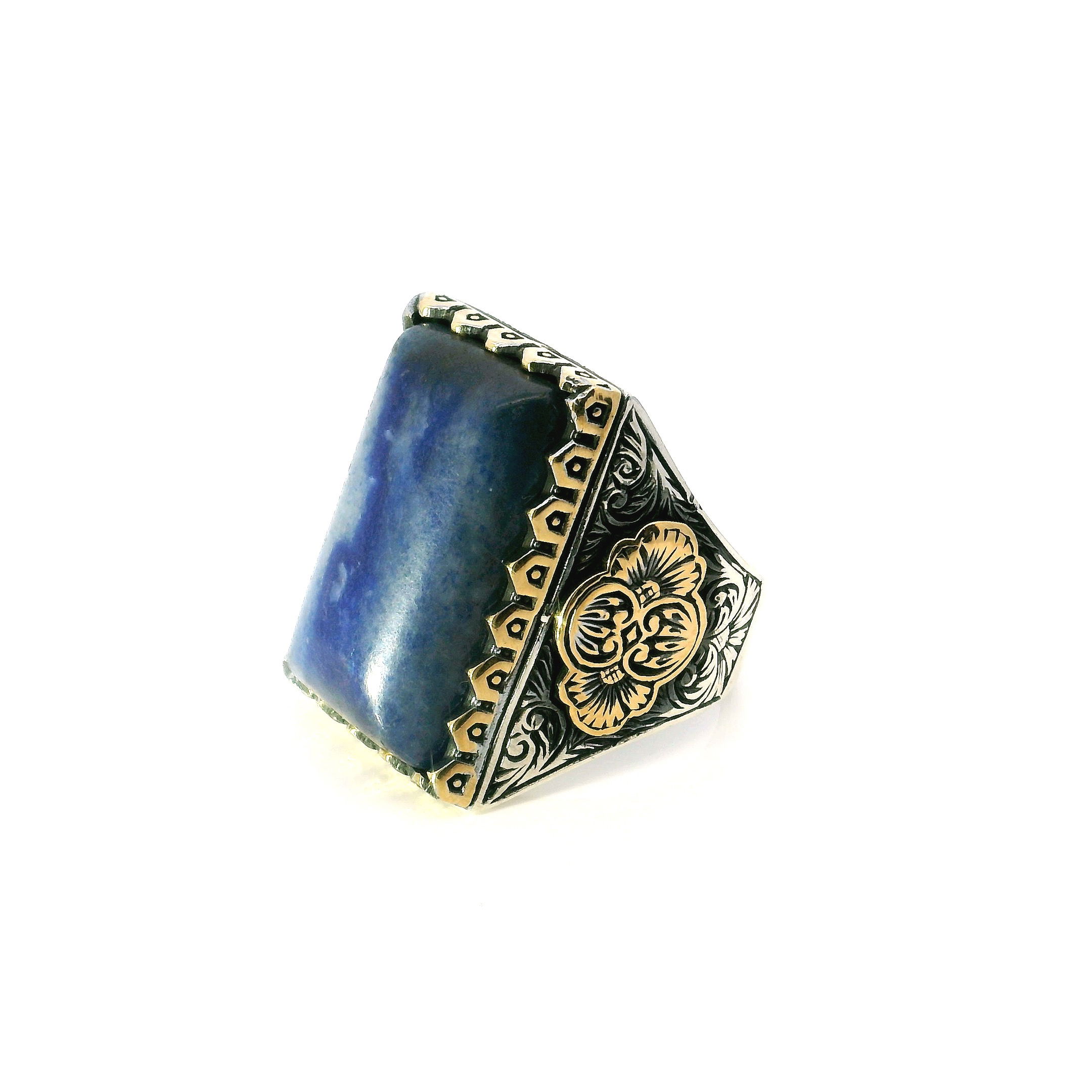 Elevate your style with this striking Sodalite Ring, masterfully crafted in solid 925 sterling silver. A bold, rectangular pillow cabochon of deep blue sodalite commands attention at the center, framed in a distinctive designer sawtooth bezel that delivers a rugged yet refined presence.Accented with rich gold vermeil, this size 12 ring blends warm contrast with modern artistry. Whether worn daily or for special occasions, it offers timeless elegance with contemporary edge—perfect for anyone who values unique gemstones and impeccable craftsmanship. Sodalite Ring - Rectangular Pillow Cabochon in Designer Sawtooth Setting in 925 Sterling Silver with Gold Vermeil Accents sz12