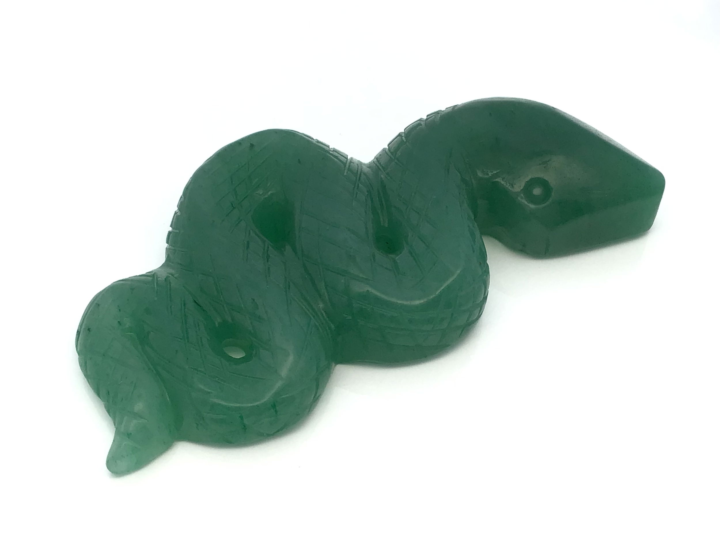 Commanding and poised, the Aventurine 4" Snake Ready-to-Strike Carving captures the raw elegance of a serpent frozen in a moment of tension and grace. Hand-carved from genuine green aventurine, this dynamic sculpture evokes transformation, protection, and sharpened awareness. Each curve of the coiled body and lifted head is rendered in rich, variegated green tones, with subtle mineral shimmer unique to aventurine.Smoothly polished and compact in size, this piece offers a striking presence—whether as a protective totem, conversation-starting décor, or symbolic gift. The natural stone’s sparkling inclusions add an otherworldly depth, enhancing the lifelike energy of the form. At once grounded and powerful, this ready-to-strike snake channels both serenity and latent strength. Aventurine 4" Snake Ready-to-Strike Carving