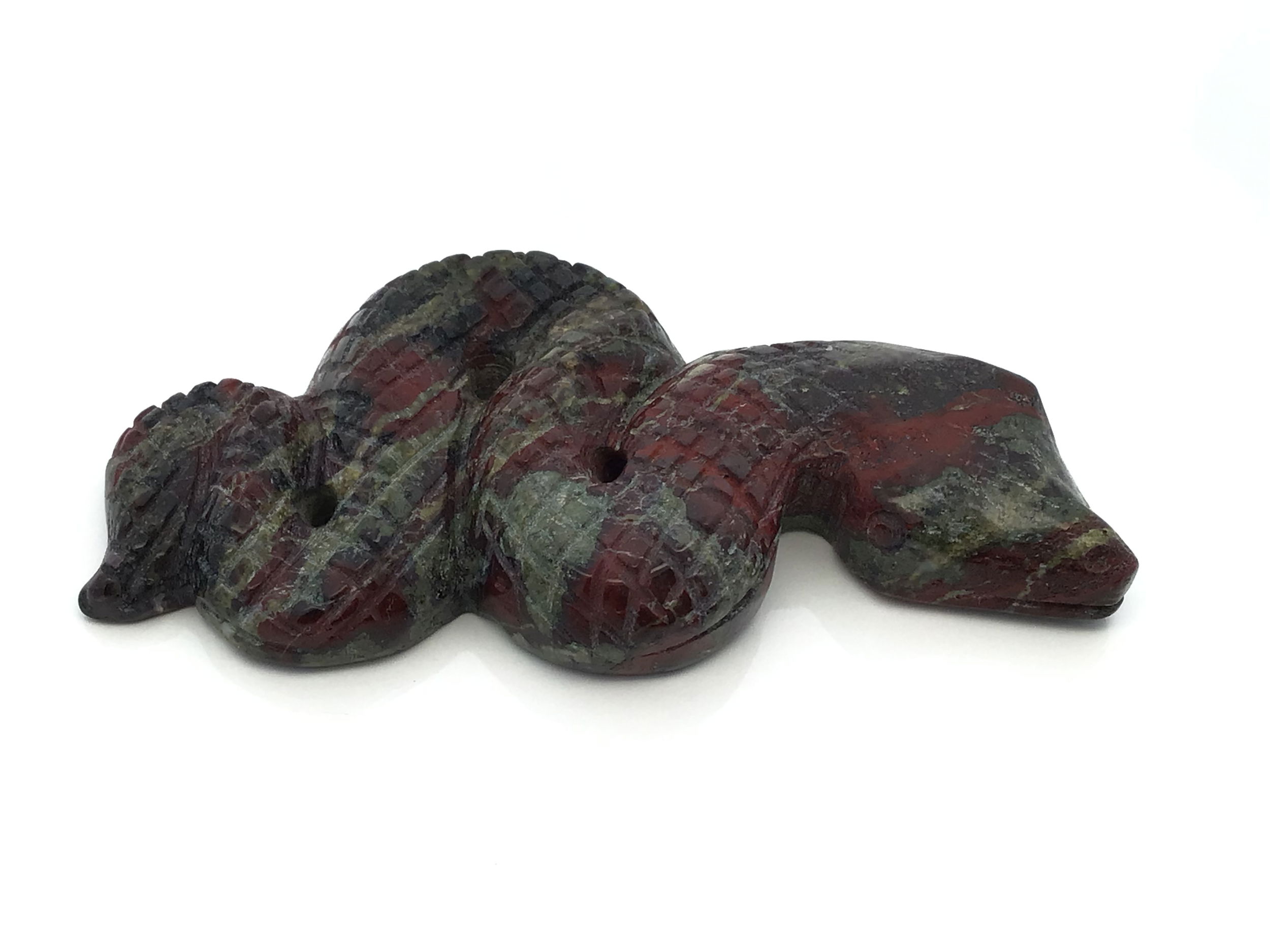 Expertly carved from genuine Dragon Bloodstone, this 4-inch snake captures the raw energy and poised strength of a serpent ready to strike. The deep greens and vivid crimson veins of the stone evoke courage, vitality, and transformation, making each piece uniquely powerful and visually striking.Ideal for crystal collections, altars, or as a meaningful gift, this hand-carved carving blends artistry with ancient symbolism. Its dynamic form and natural patterns make it a compelling talisman and a stunning accent for any space. Dragon Bloodstone 4" Snake Ready-to-Strike Carving