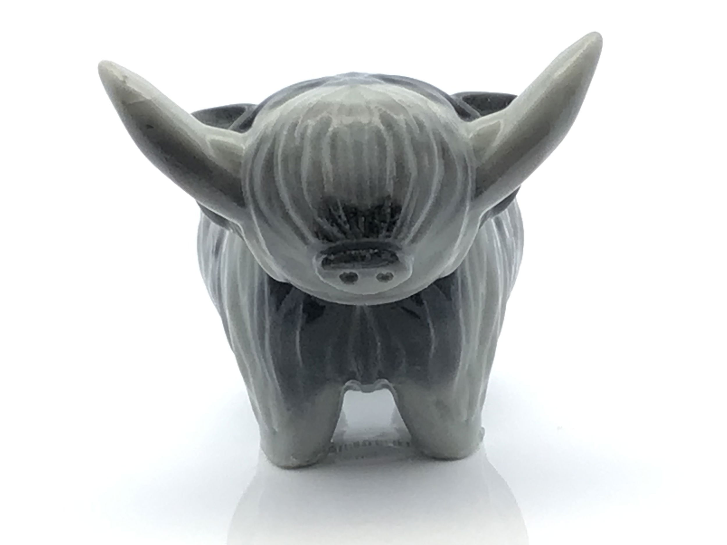 Hand-carved from genuine Gray Zebra Jasper, also known as Taiji Jasper, this 3.5" cow sculpture showcases soft gray tones swirled with ivory bands, each piece naturally one-of-a-kind. Polished to a smooth finish, the serene patterns and gentle curves bring calming energy and quiet beauty to any shelf, altar, or workspace.A symbol of nurturing, stability, and abundance, the cow holds deep meaning across cultures. This charming carving offers both decorative charm and grounding presence—ideal for crystal lovers, collectors of animal figures, or anyone drawn to the steady, harmonious energy of jasper. Gray Zebra Jasper 3.5" Cow (Taiji Jasper) Carving